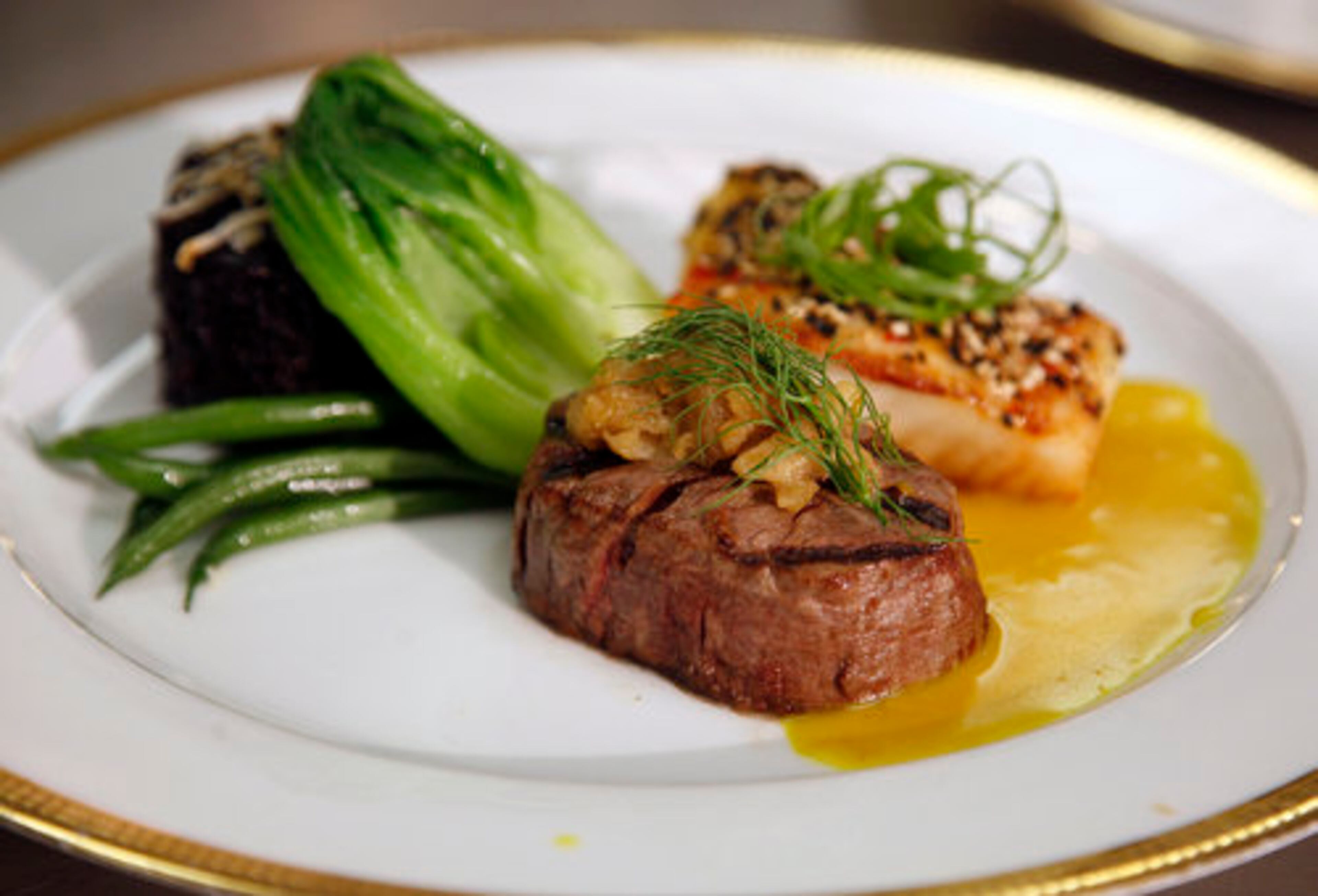 The surf-and-turf entree features grilled beef tenderloin with caramelized fennel marmalada and a sauteed mild chili sesame crusted filet of Pacific sea bass.