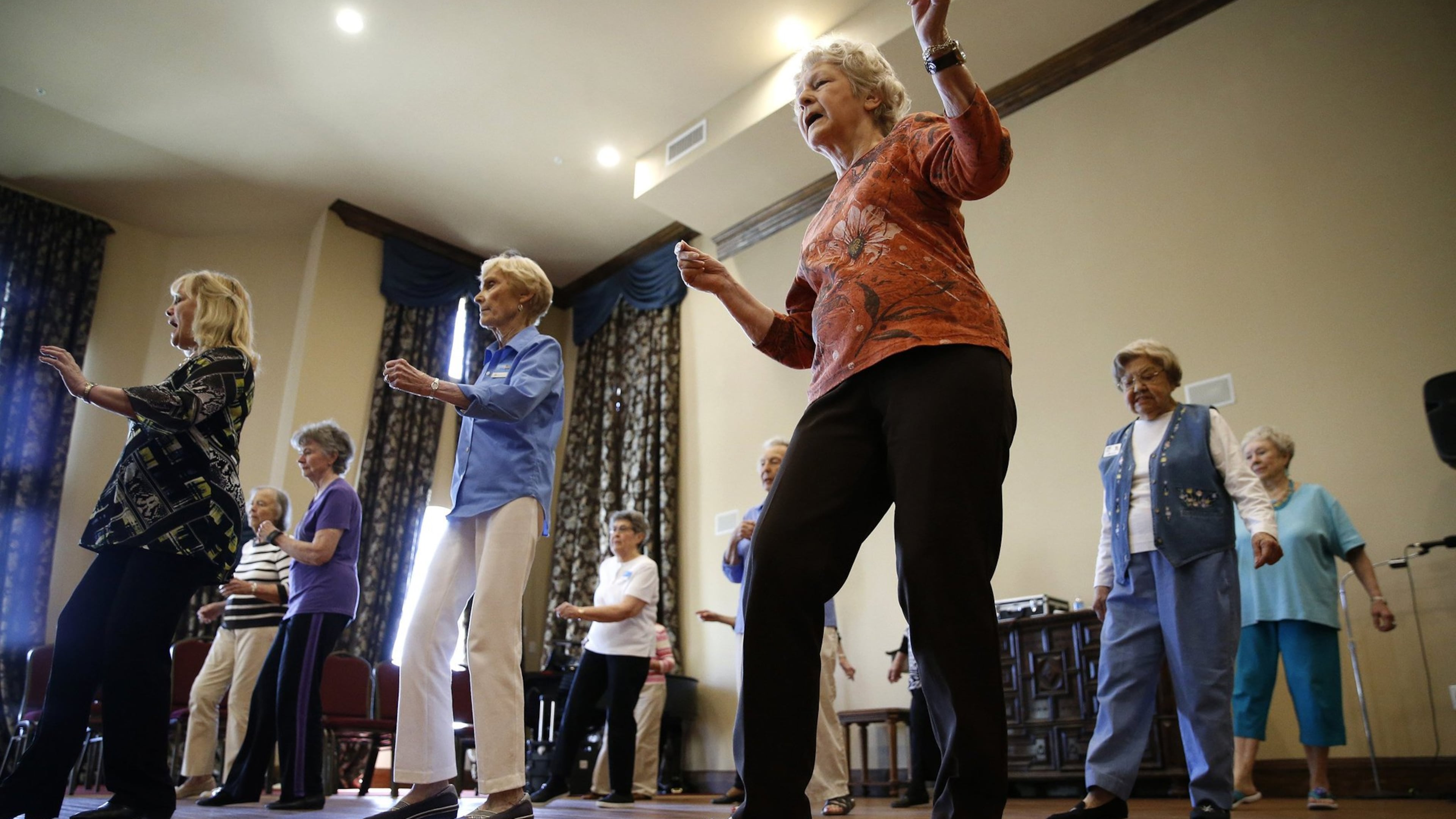 Sarah Winlock (in orange) dances during a line dancing class for seniors at Atria Canyon Creek in Plano, Texas on April 16, 2018. (Nathan Hunsinger/Dallas Morning News/TNS)