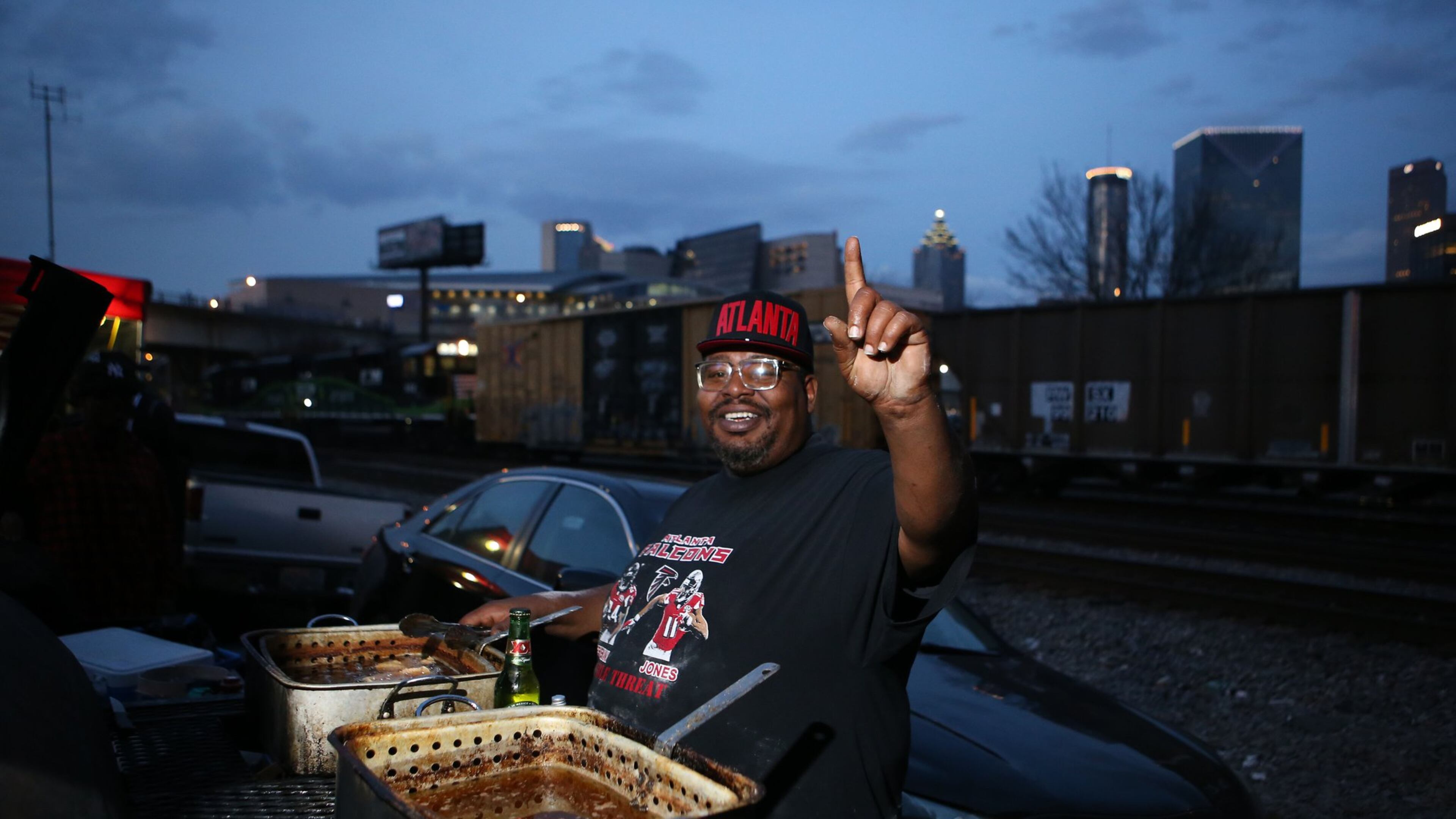 Marcus England, a lifelong Atlanta resident, has tailgated in The Gulch for years, where he fries fish, chicken, and pork chops one one side of his grill, and grills burgers, chicken, turkey sausage, and steak on the other. (Photo by HENRY TAYLOR)