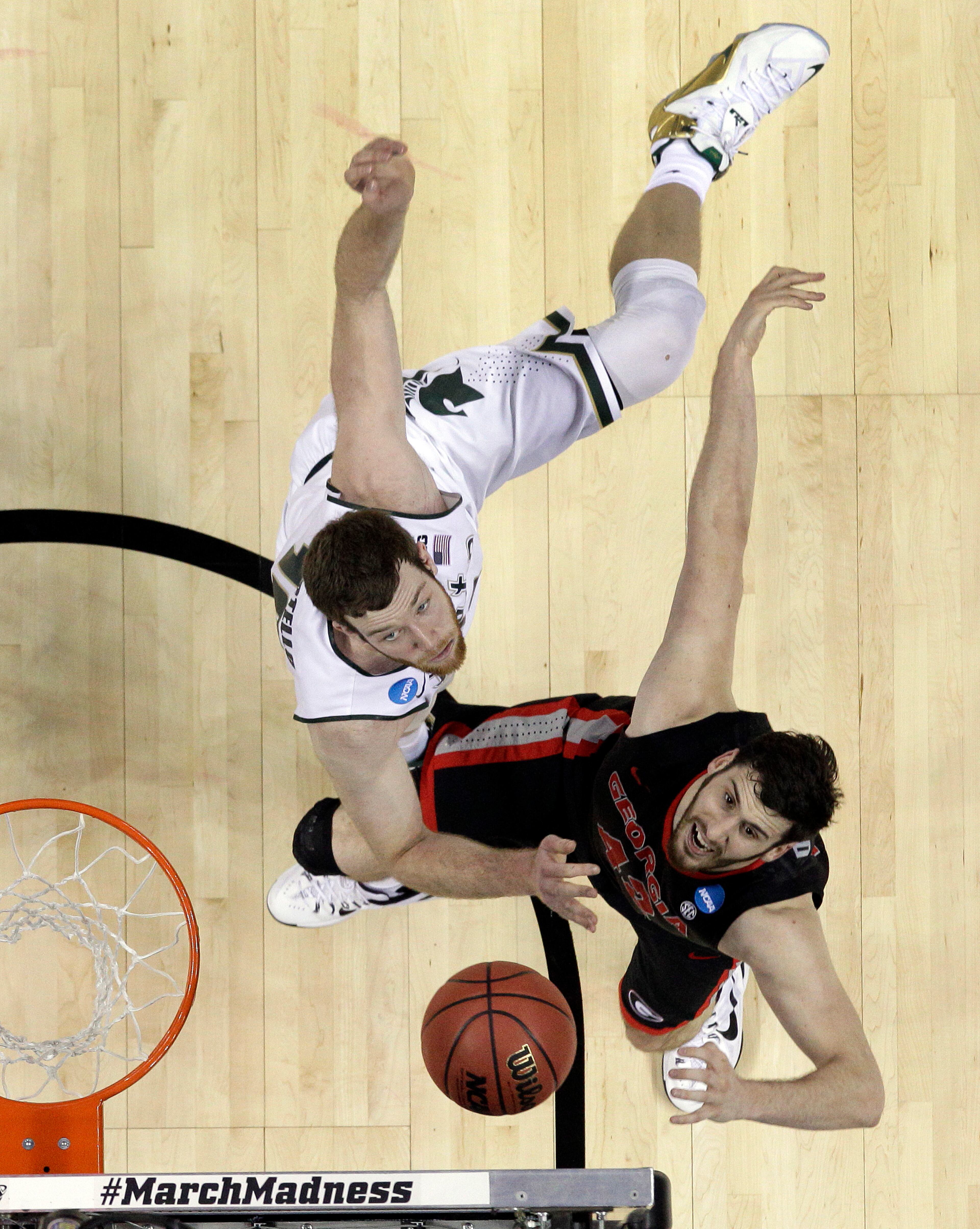 Georgia's Nemanja Djurisic, right, and Michigan State's Matt Costello, left, battle for a rebound during the second half of an NCAA tournament college basketball game in the Round of 64 in Charlotte, N.C., Friday, March 20, 2015. Michigan State won 70-63. (AP Photo/Gerald Herbert)