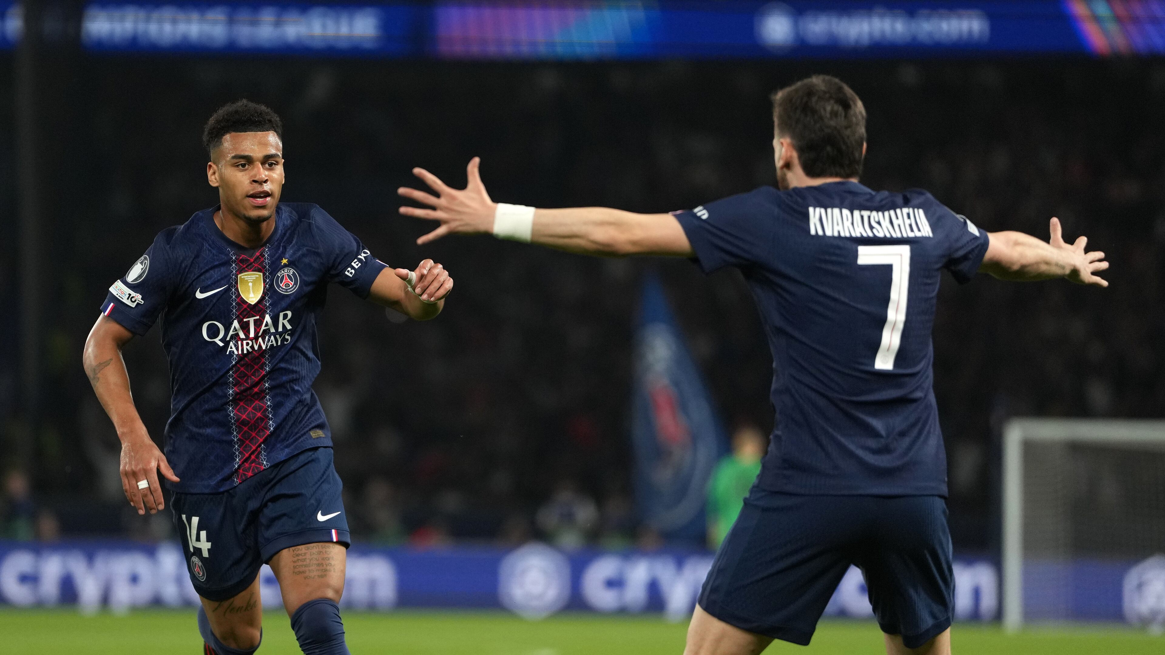 PSG's Desire Doue, left, celebrates with PSG's Khvicha Kvaratskhelia after scoring the opening goal during the Champions League quarterfinal first leg soccer match between Paris Saint-Germain and Liverpool in Paris, Wednesday, April 8, 2026. (AP Photo/Thibault Camus)
