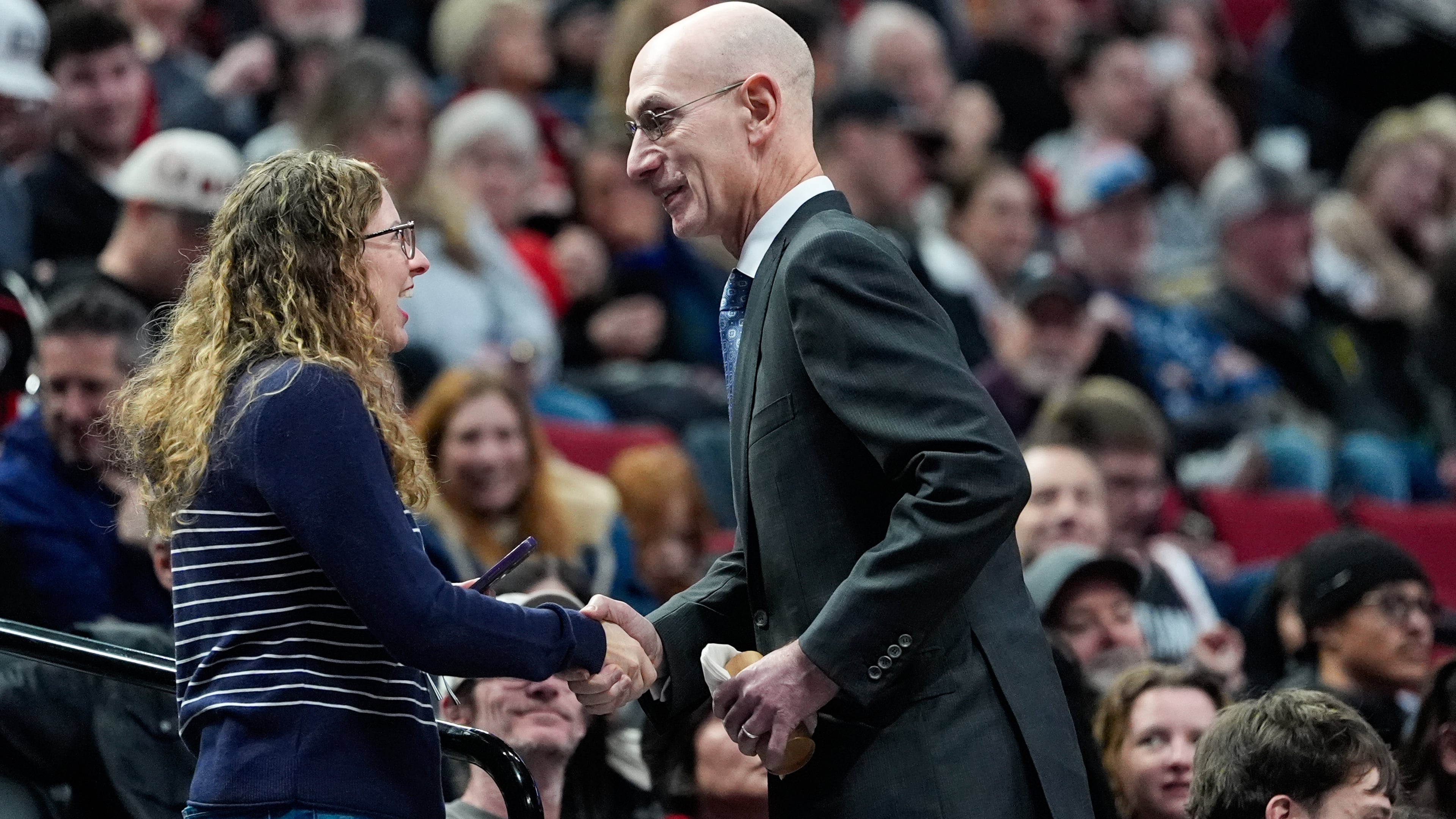NBA commissioner Adam Silver greets a fan during an NBA basketball game between the Portland Trail Blazers and the Utah Jazz, Friday, March 13, 2026, in Portland, Ore. (AP Photo/Jenny Kane)