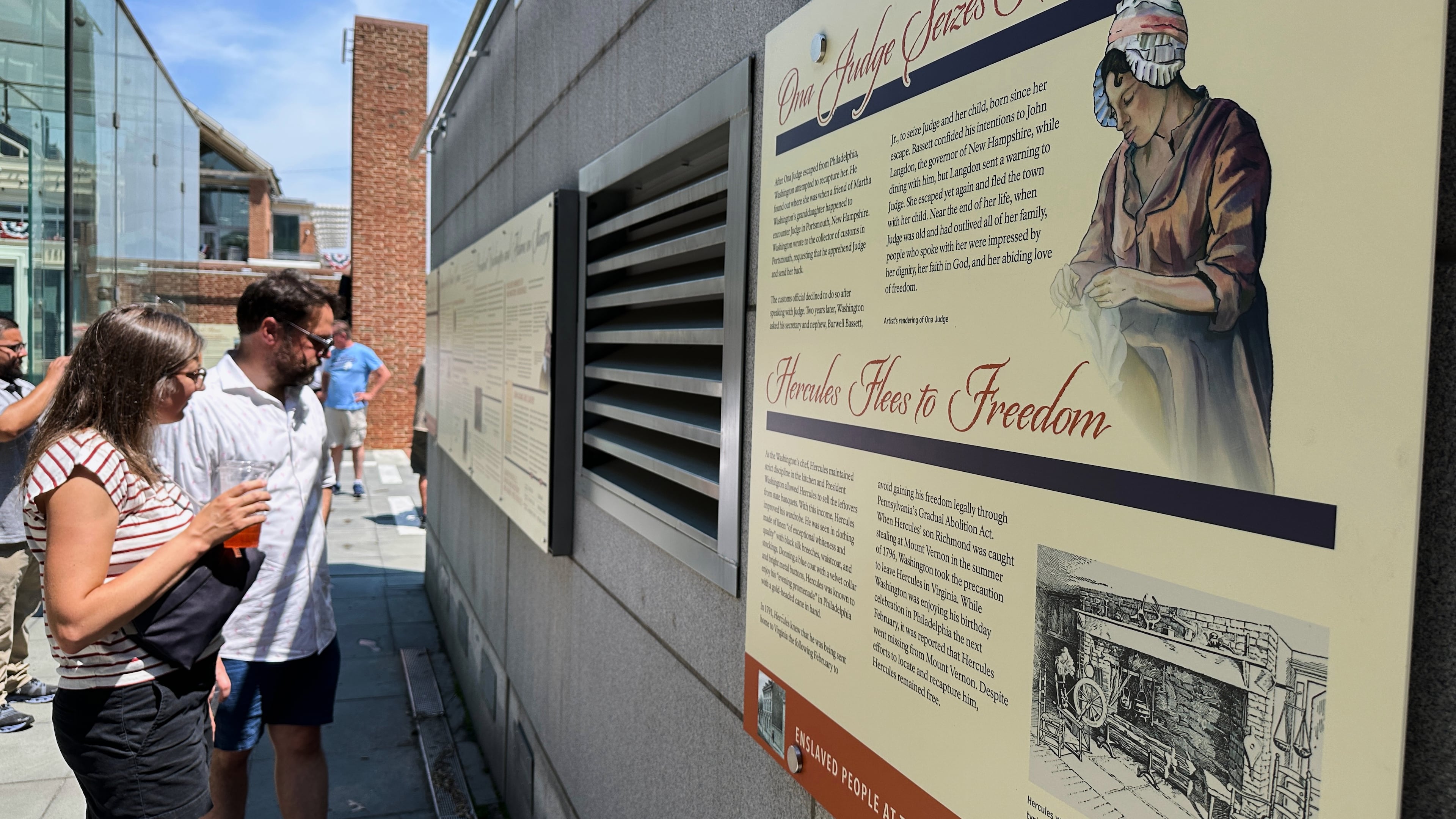 Visitors view the reinstalled educational panels about slavery at the site of President George Washington's home in Philadelphia, Wednesday, July 15, 2026. (AP Photo/Tassanee Vejpongsa)