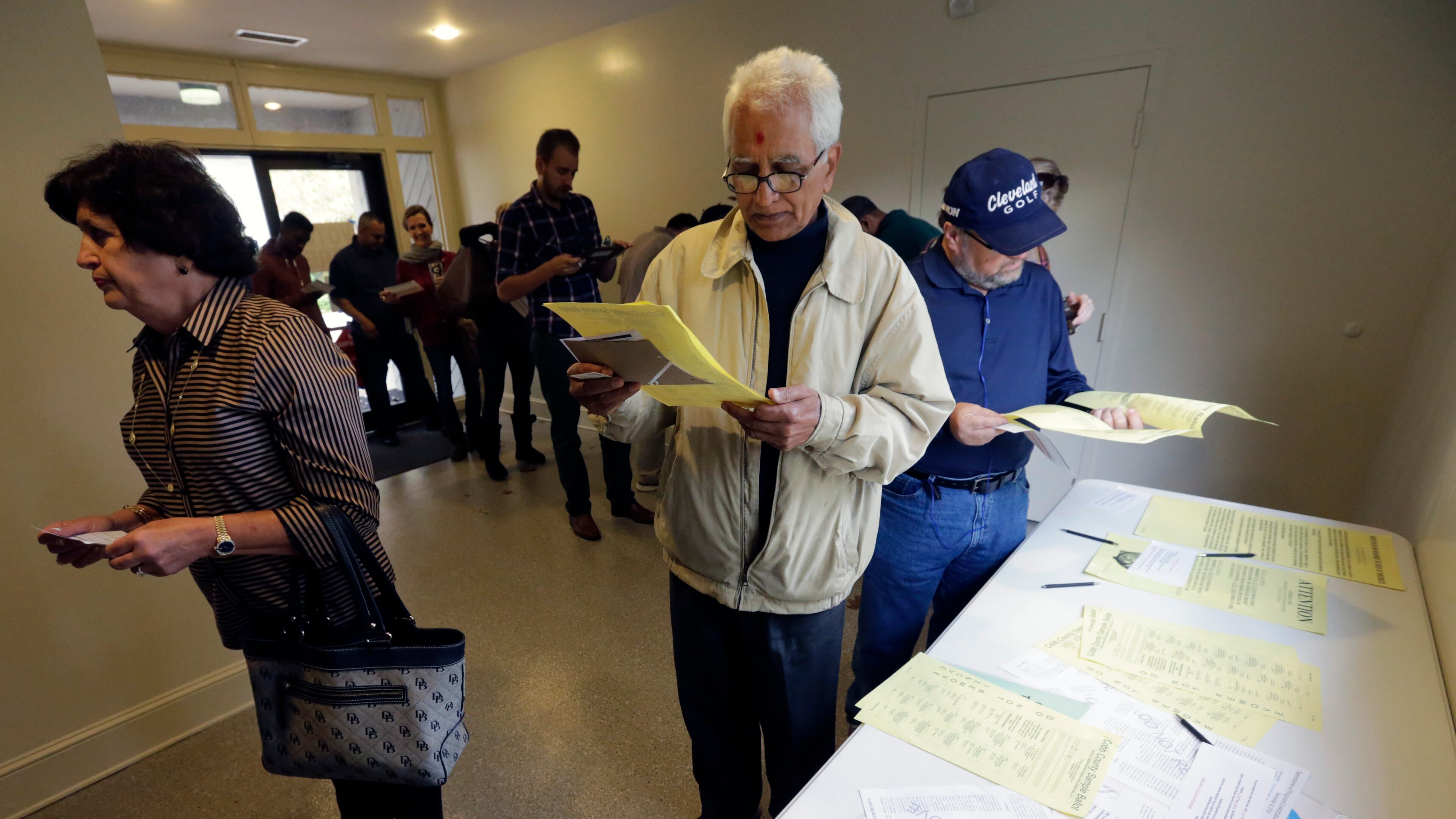 Manubhai Patel looks over the Cobb County ballot as he waits in line to vote. The line was long but moved quickly as voters lined up to at the Life Church Smyrna Assembly of God on Tuesday. BOB ANDRES /BANDRES@AJC.COM