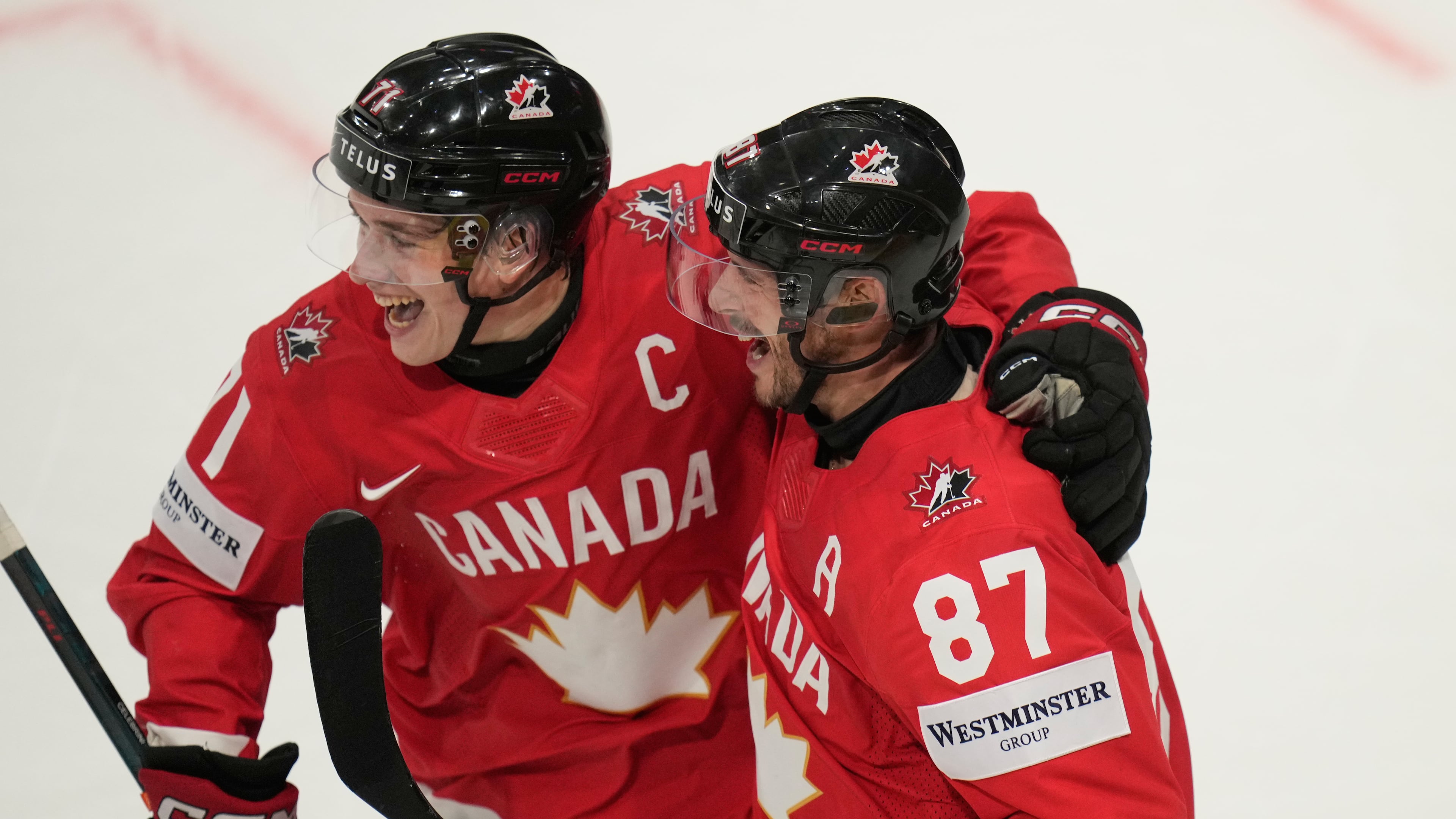 Canada's Sidney Crosby (87) celebrates with Macklin Celebrini (71) after scoring a goal during the third period of the 2026 IIHF Men's Ice Hockey World Championship quarterfinal match between Canada and United States, in Fribourg, Switzerland, Thursday, May 28, 2026. (AP Photo/Darko Bandic)