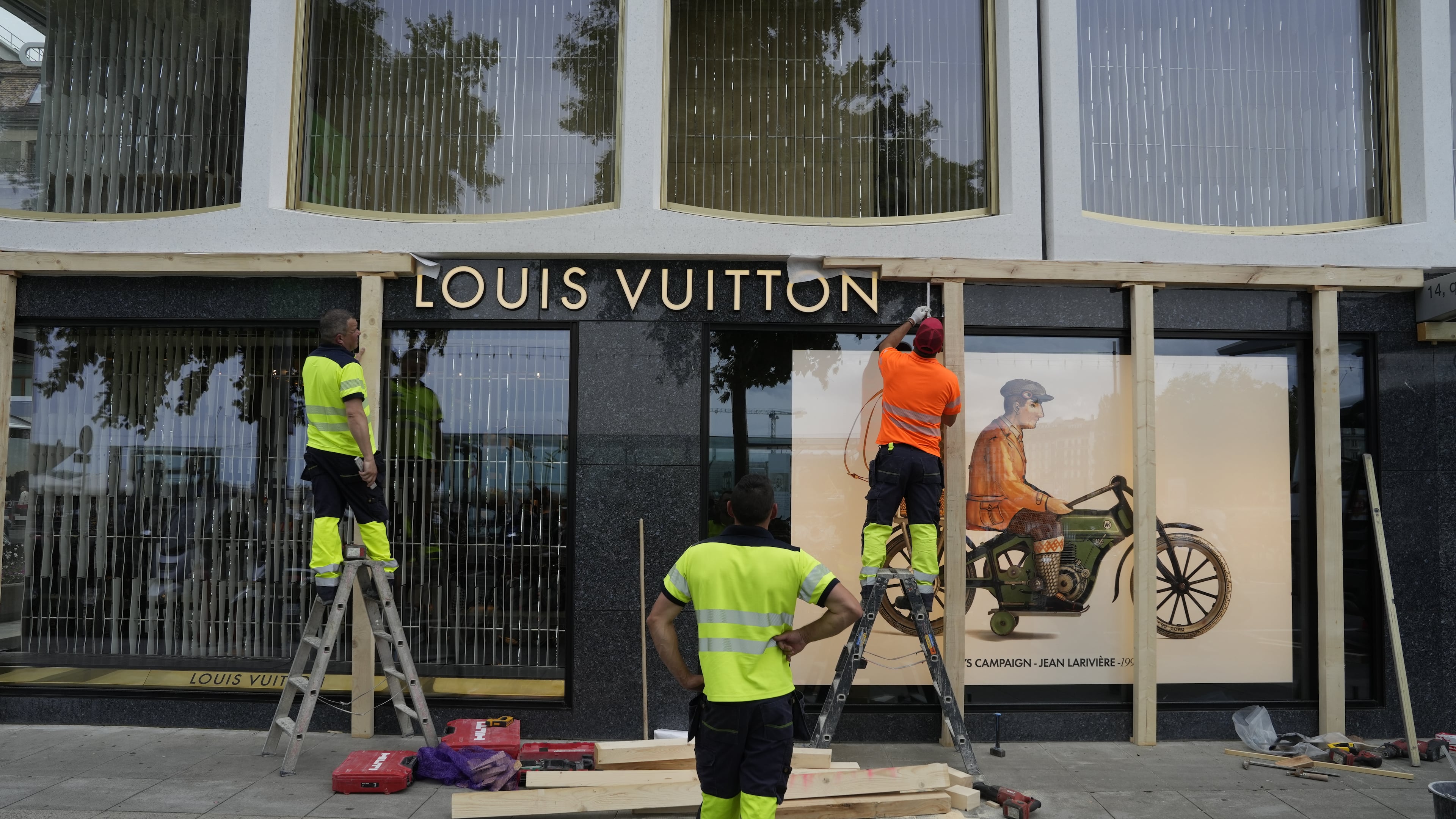 Construction workers board up a shop window, ahead of expected protests for the G7 summit, in Geneva, Switzerland, Monday, June 8, 2026. (AP Photo/Baz Ratner)