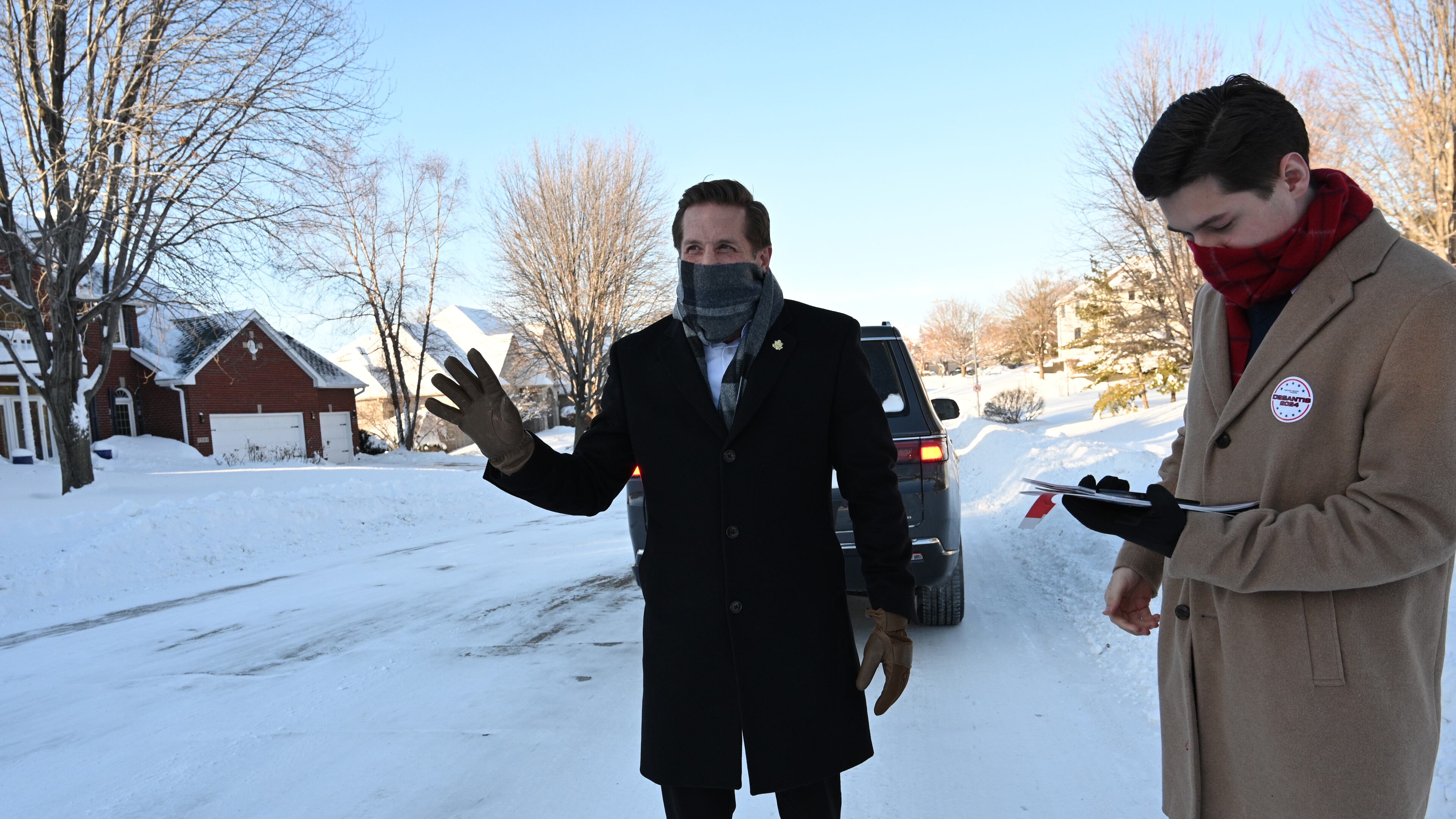 U.S. Rep. Rich McCormick assisted by his aid Jonathan Casas waves to a car as he is knocking on doors to encourage to vote for Republican presidential candidate Florida Gov. Ron DeSantis in a neighborhood, Sunday, January 14, 2024, in West Des Moines, Iowa. (Hyosub Shin / Hyosub.Shin@ajc.com)