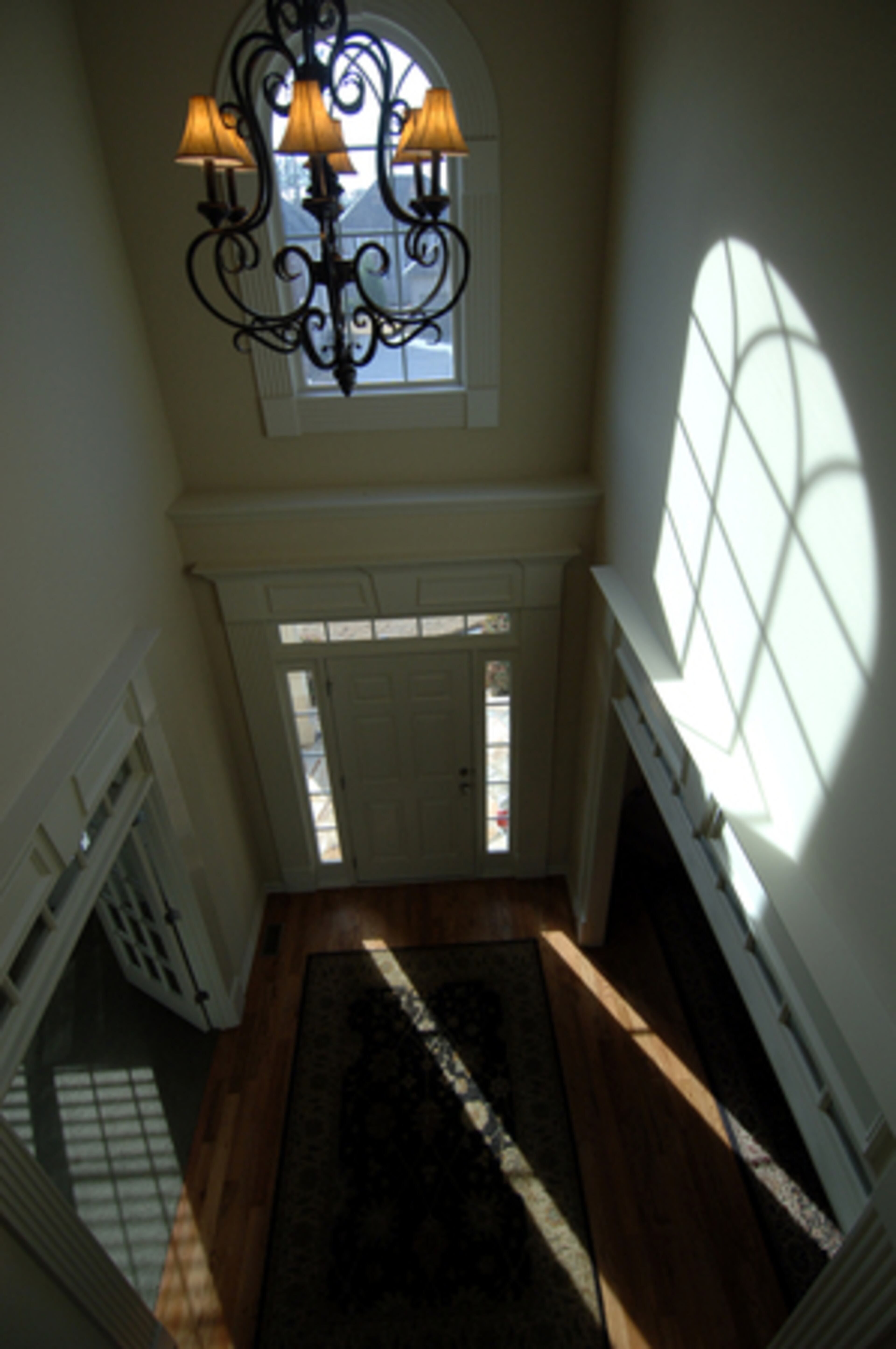 Back upstairs, the light plays off the wall in the foyer.