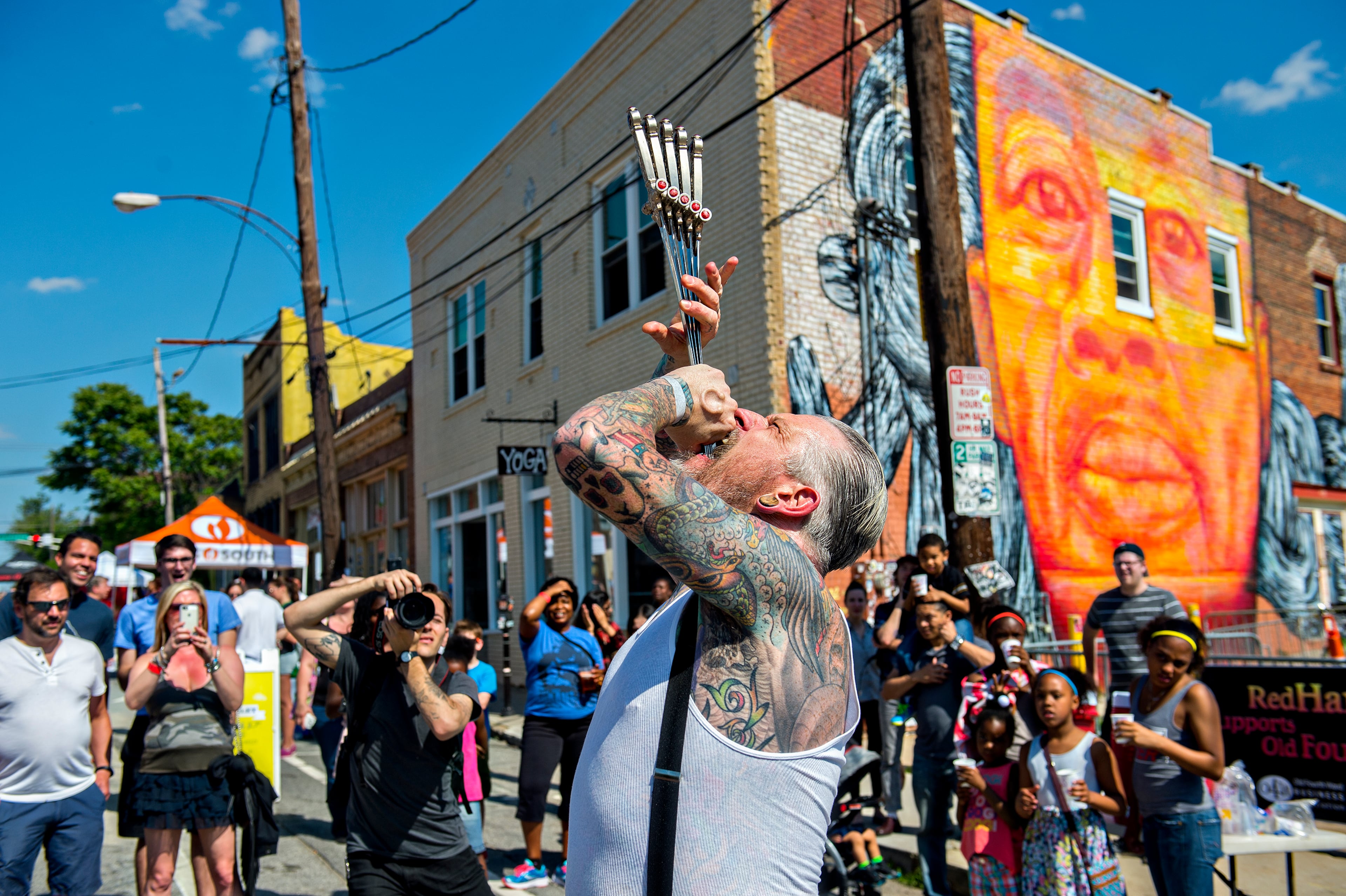 Captain Stab Tuggo swallows a handful of swords during the Fire in the Fourth Festival in the Old Fourth Ward neighborhood of Atlanta on Saturday, May 2, 2015. The first annual festival featured a live musical and fire performances, firefighter muster relays, and aerial acrobatics by the Imperial Opa Circus. JONATHAN PHILLIPS / SPECIAL