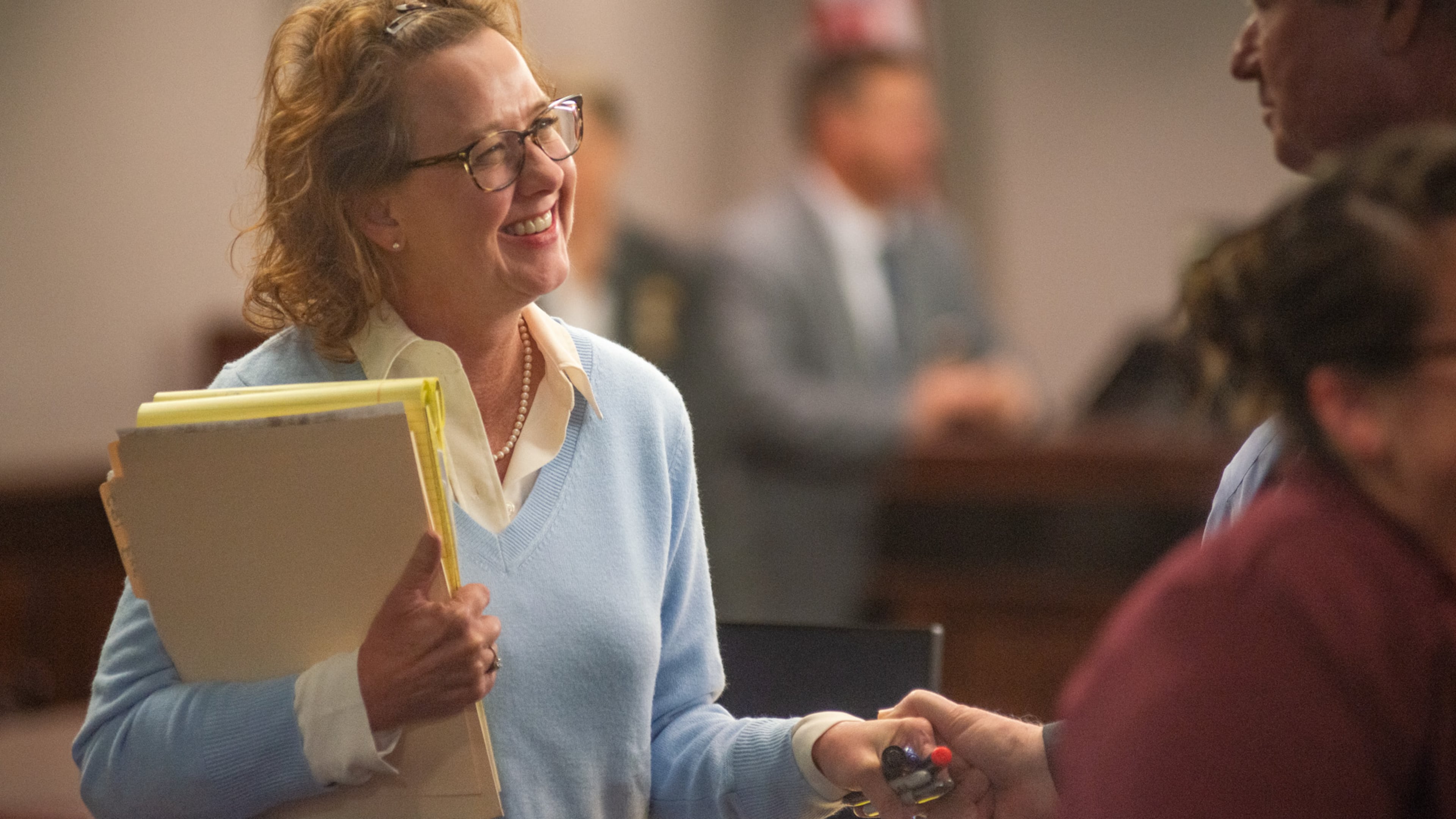 Former District Attorney Jackie Johnson smiles at a supporter who took her hand Monday after Senior Judge John R. Turner dismissed one of the two charges she faced.