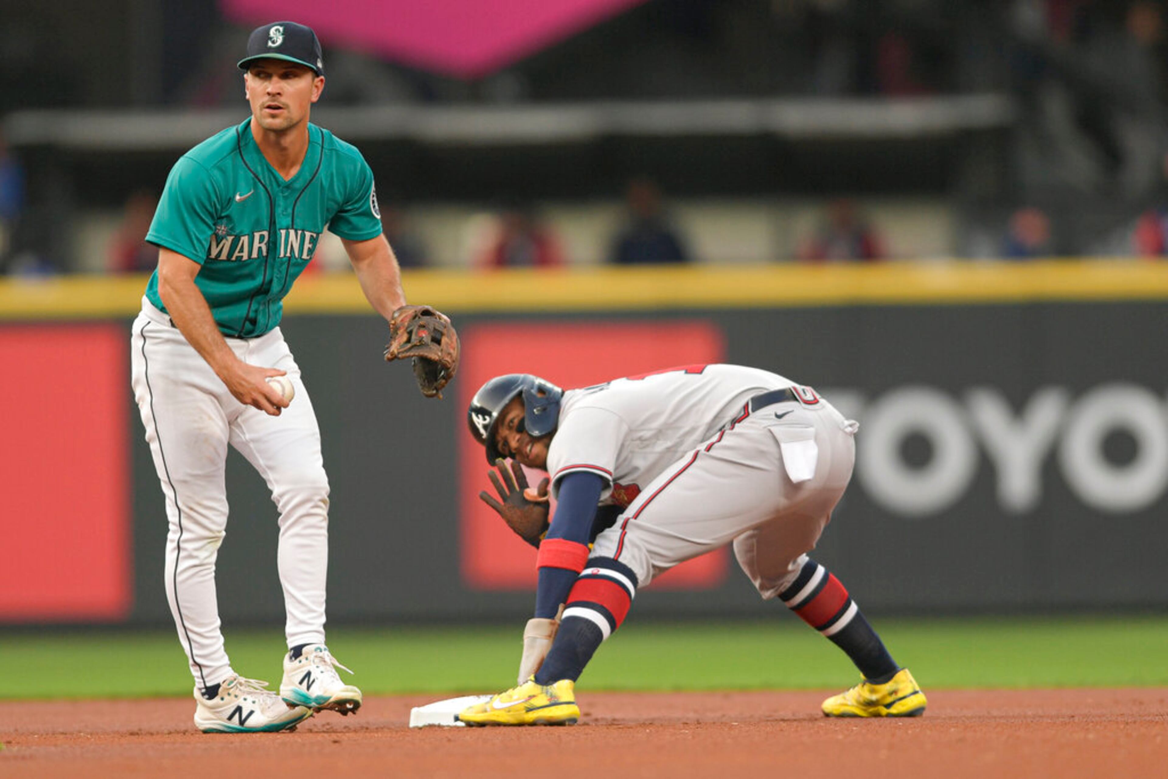Atlanta Braves' Ronald Acuna Jr., right, reacts after stealing second base during the first inning of a baseball game against the Seattle Mariners, Friday, Sept. 9, 2022, in Seattle. (AP Photo/Caean Couto)