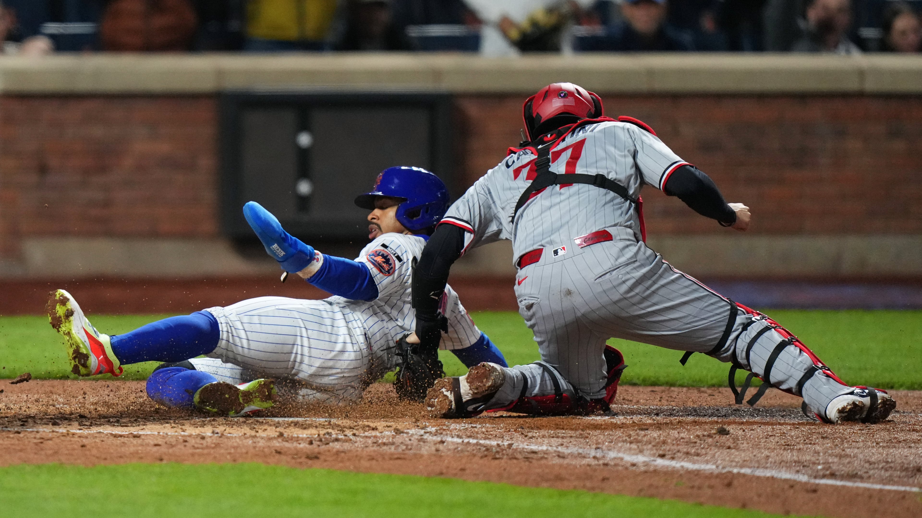 New York Mets' Francisco Lindor, left, slides past Minnesota Twins catcher Victor Caratini to score on a double by Francisco Alvarez during the fourth inning of a baseball game Wednesday, April 22, 2026, in New York. (AP Photo/Frank Franklin II)