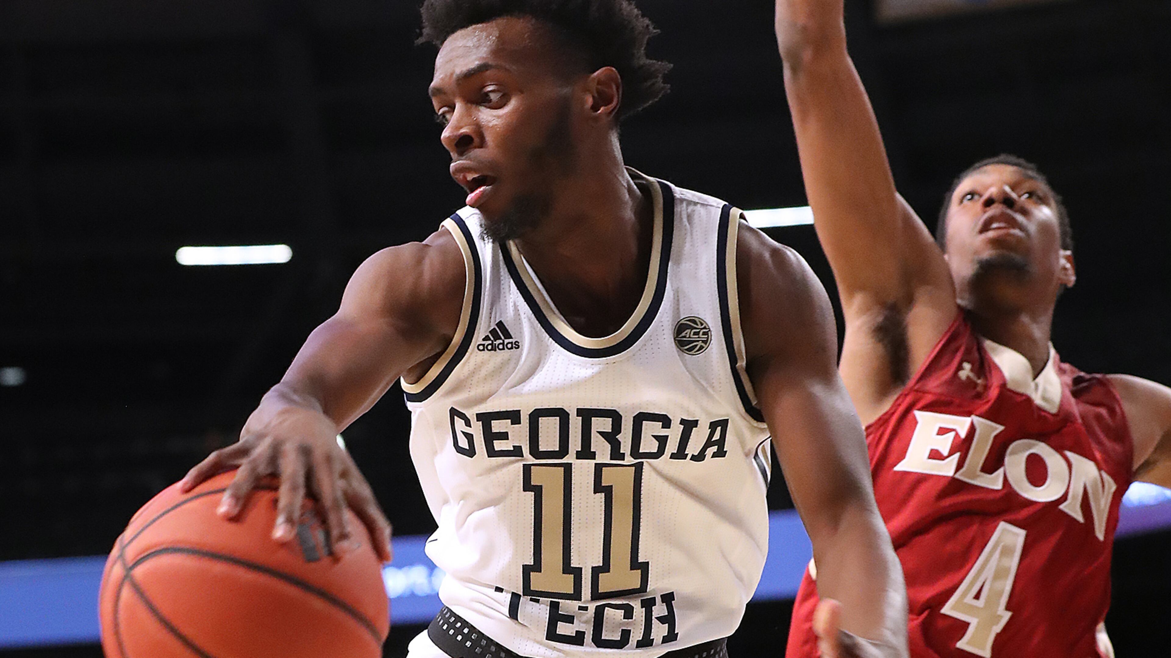Georgia Tech guard Bubba Parham passes off under the basket against Elon guard Marcus Sheffield II Monday, Nov. 11, 2019, at McCamish Pavilion in Atlanta.
