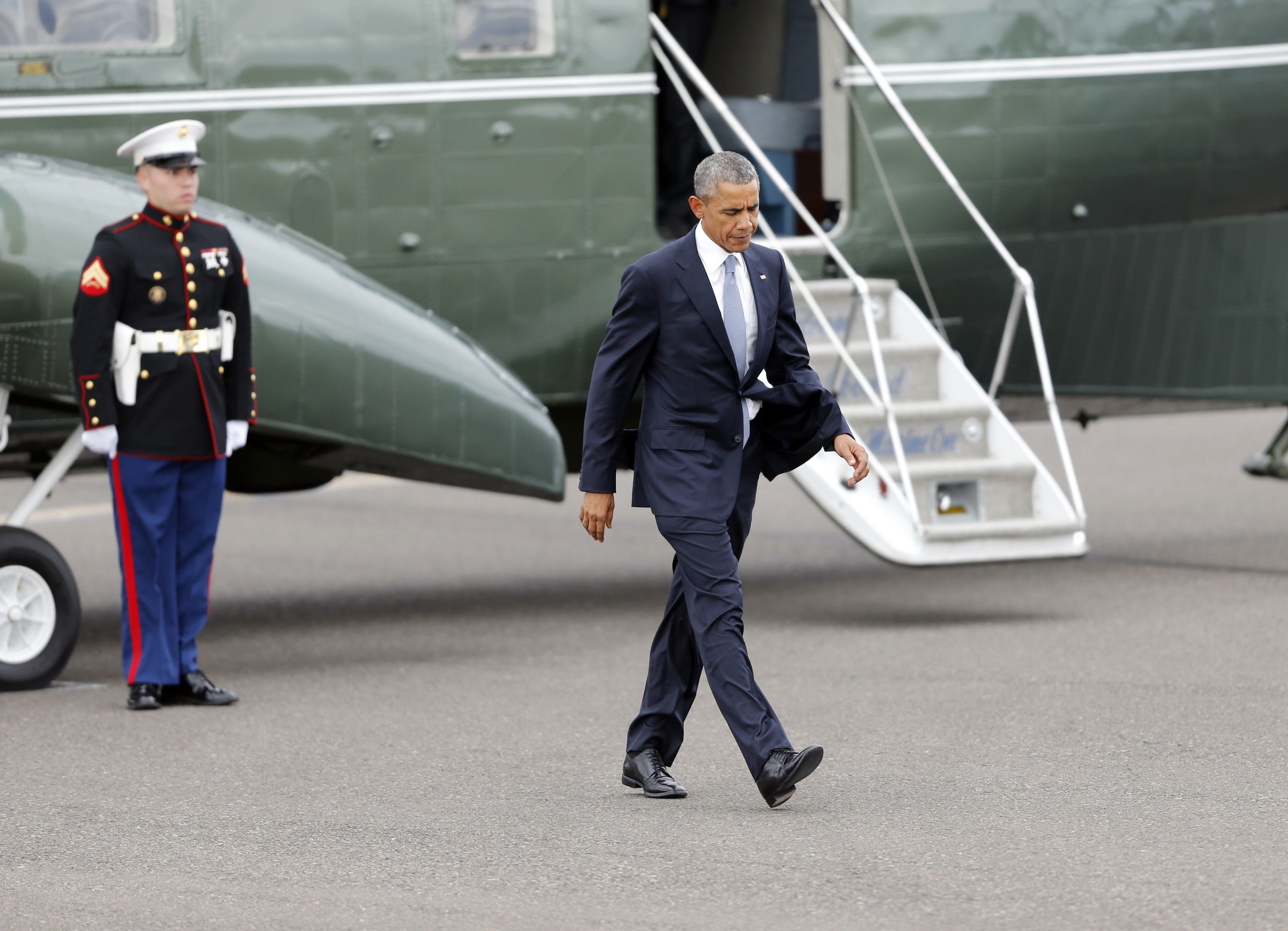 President Barack Obama walks across the tarmac after leaving Marine One at the Eugene, Ore. airport on Friday, Oct. 9, 2015. The President met privately with families of victims of the Umpqua Community College shooting. (AP Photo/Timothy J. Gonzalez)