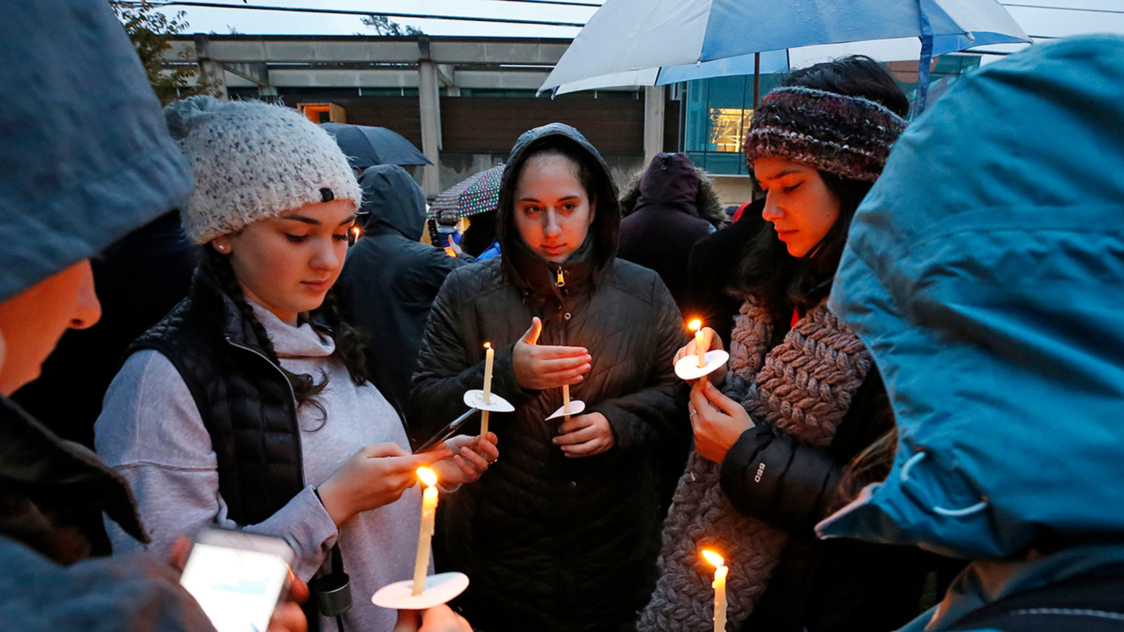Holding candles, a group of girls wait for the start of a memorial vigil at the intersection of Murray Ave. and Forbes Ave. in the Squirrel Hill section of Pittsburgh, for the victims of the shooting at the Tree of Life Synagogue where a shooter opened fire, killing 11 and wounding six, including four police officers, Saturday, Oct. 27, 2018. (AP Photo/Gene J. Puskar)