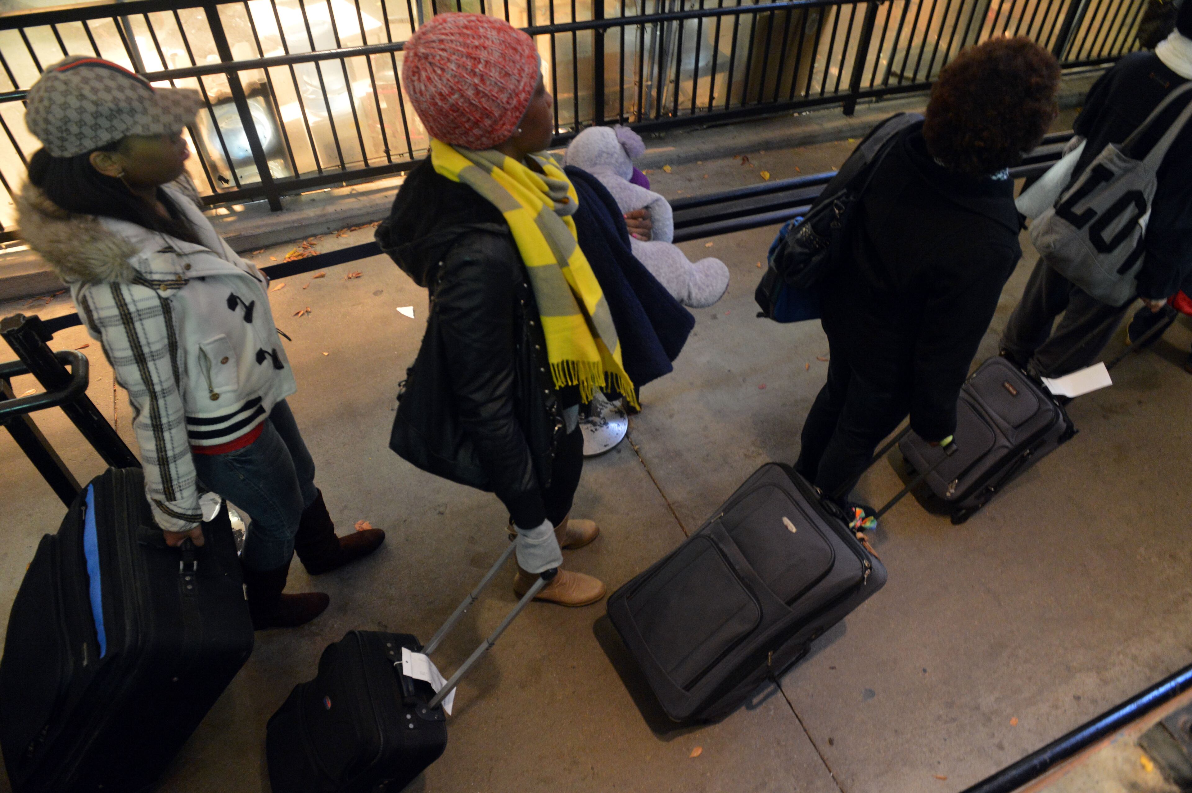 Holiday travelers head towards buses at the Greyhound bus station in downtown Atlanta, on the day before Thanksgiving, Wednesday, November 27, 2013. Blustery winds and cold temperatures had many travelers bundled up against the pre-holiday weather. KENT D. JOHNSON / KDJOHNSON@AJC.COM