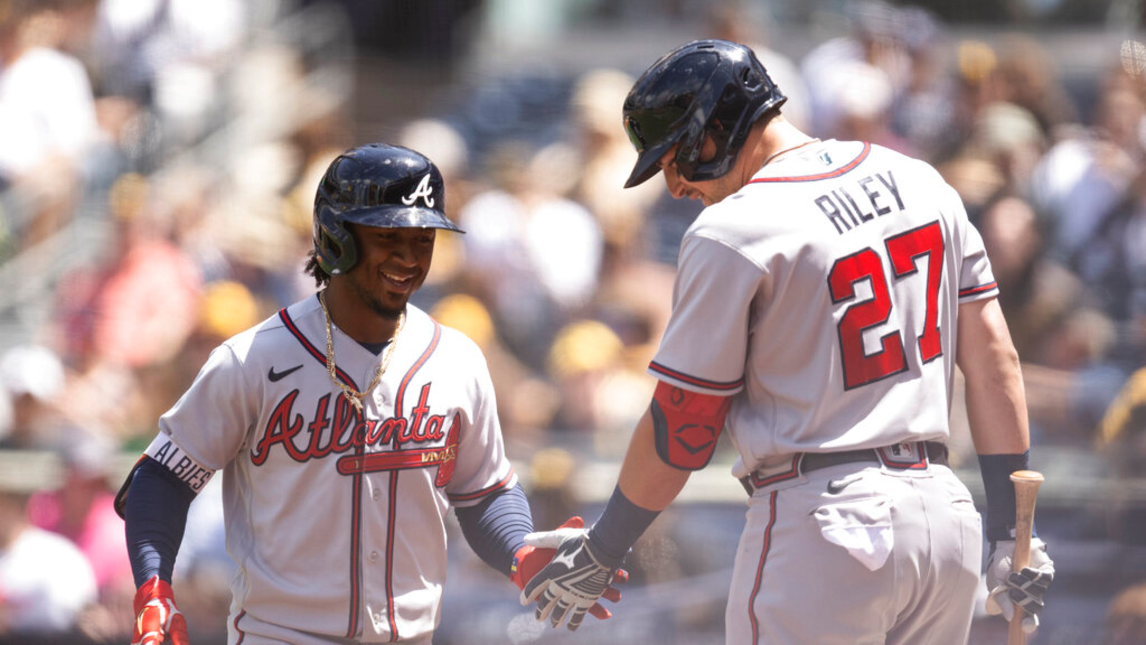 Atlanta Braves' Ozzie Albies, left, celebrates his solo home run with Austin Riley during the first inning of a baseball game against the San Diego Padres in San Diego, Saturday, April 16, 2022. (AP Photo/Kyusung Gong)