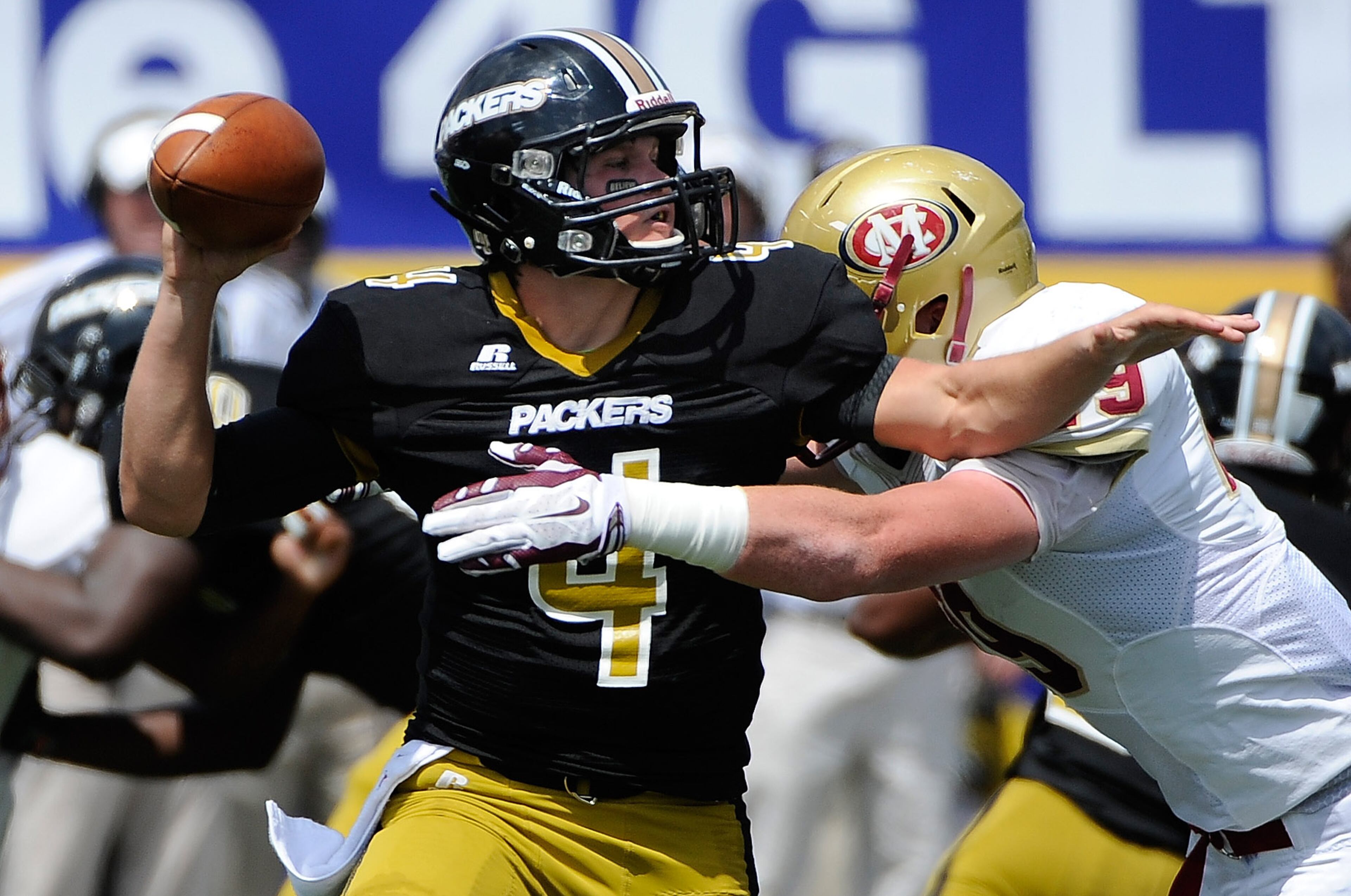 Colquitt quarterback Chase Parrish (4) is pressured by Mill Creek's Peyton Moore (29) in the first half of their Corky Kell Classic football game at Walter H. Cantrell Stadium on Saturday, Aug. 23, 2014, in Powder Springs, Ga. David Tulis / AJC Special