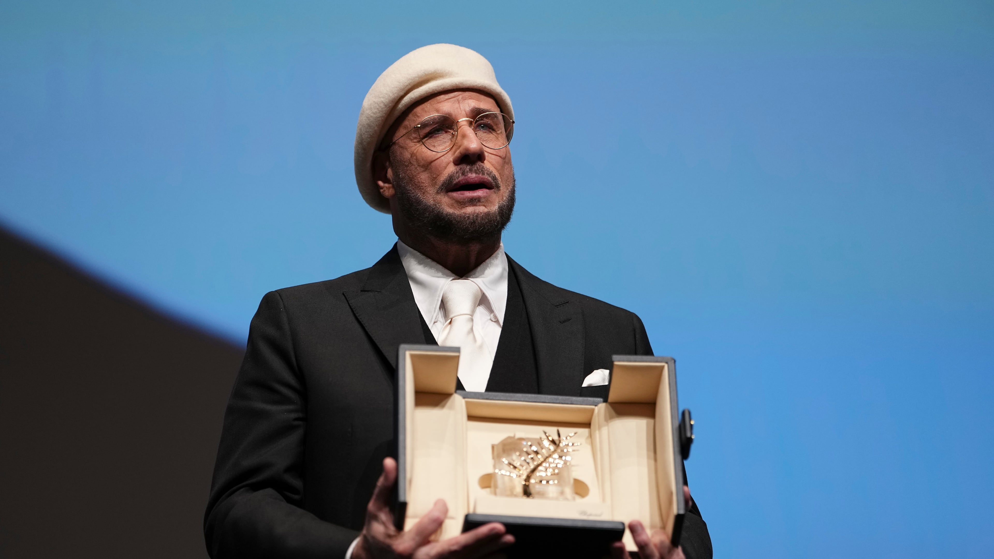 John Travolta holds his honorary Palme d'Or during the 79th international film festival, Cannes, southern France, Friday, May 15, 2026. (Photo by Scott A Garfitt/Invision/AP)