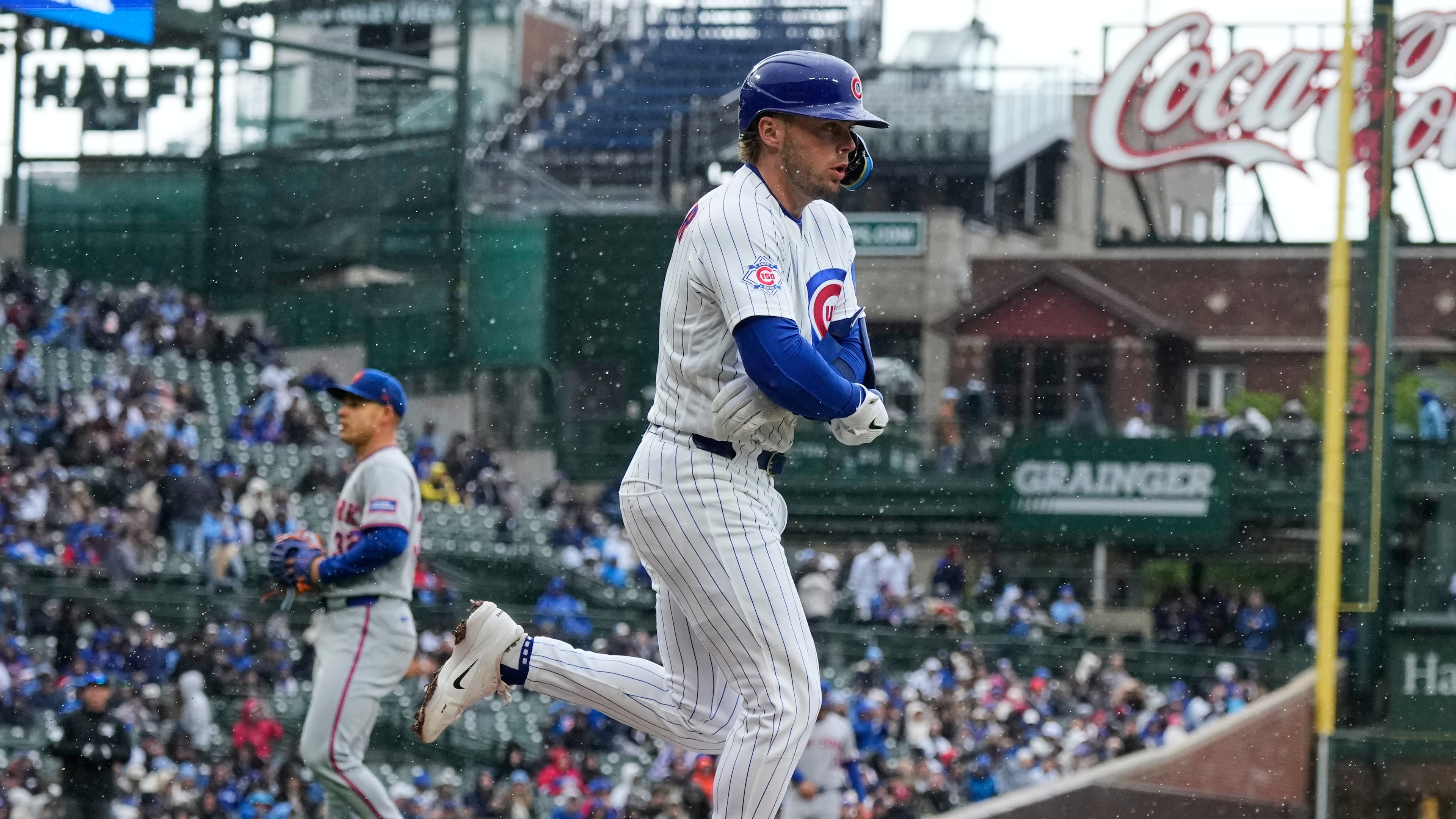Chicago Cubs' Nico Hoerner, foreground, walks to first during the first inning of a baseball game against the New York Mets in Chicago, Sunday, April 19, 2026. (AP Photo/Nam Y. Huh)
