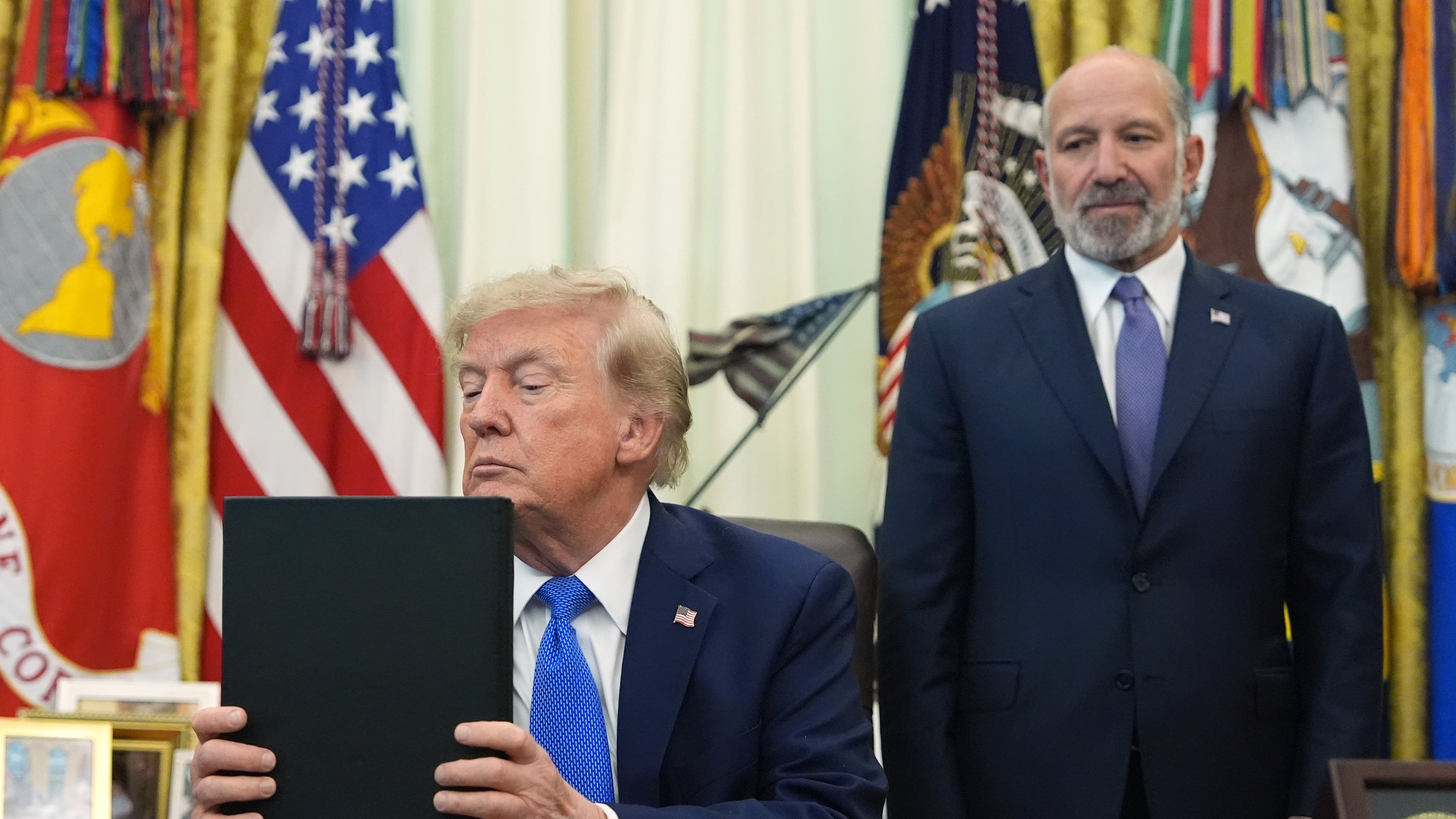 President Donald Trump listens before signing executive orders in the Oval Office of the White House, Thursday, Aug. 6, 2026, in Washington, as Commerce Secretary Howard Lutnick watches. (AP Photo/Alex Brandon)