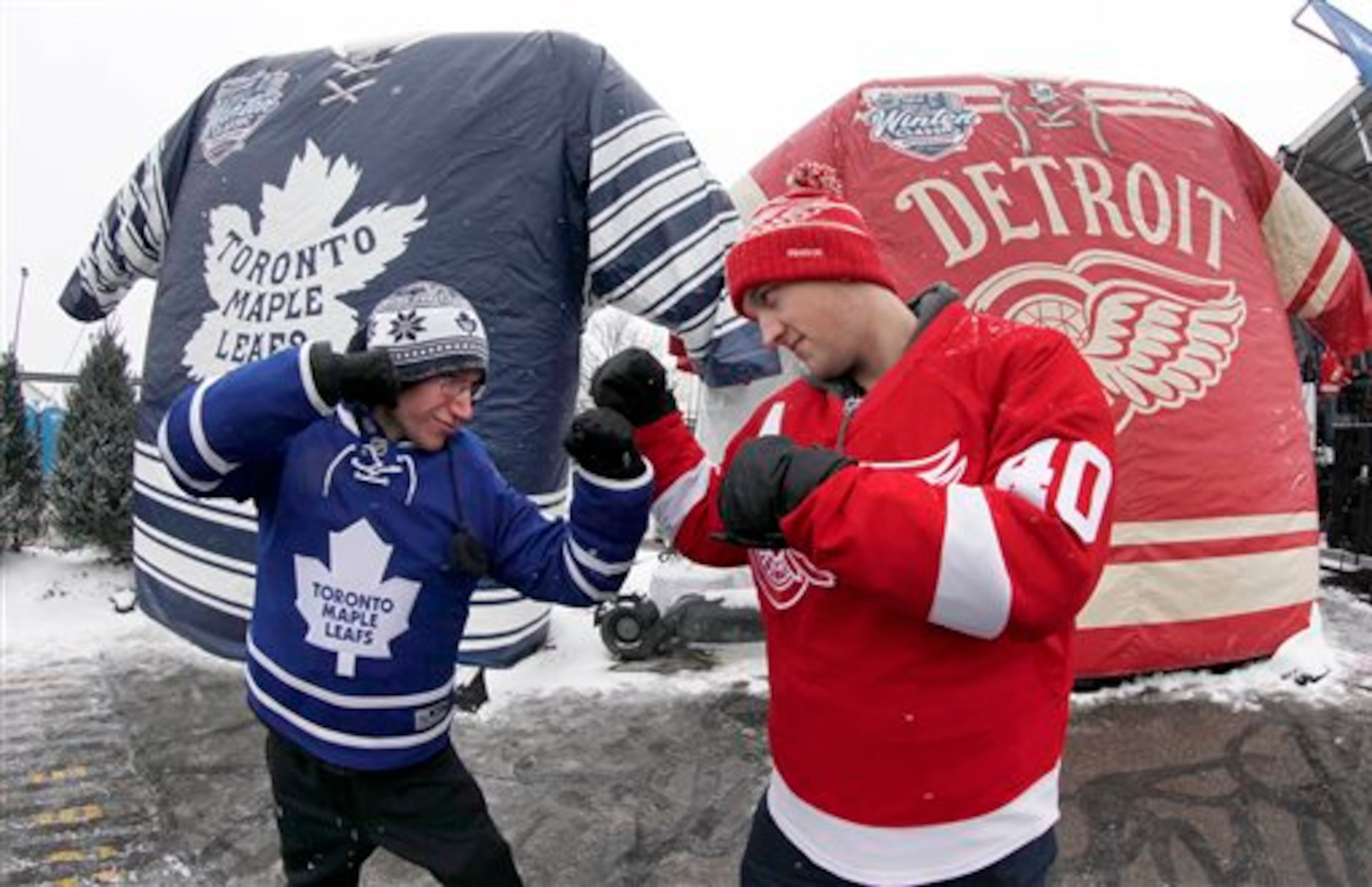 Nathan Dunville, of Halifax, Nova Scotia, left, and Adam Boutilier, of Cole Harbour, Nova Scotia, pose for family photographs at the NHL Winter Classic hockey game at Michigan Stadium in Ann Arbor, Mich., Wednesday, Jan, 1. 2014, where the Detroit Red Wings play the Toronto Maple Leafs. (AP Photo/Paul Sancya)