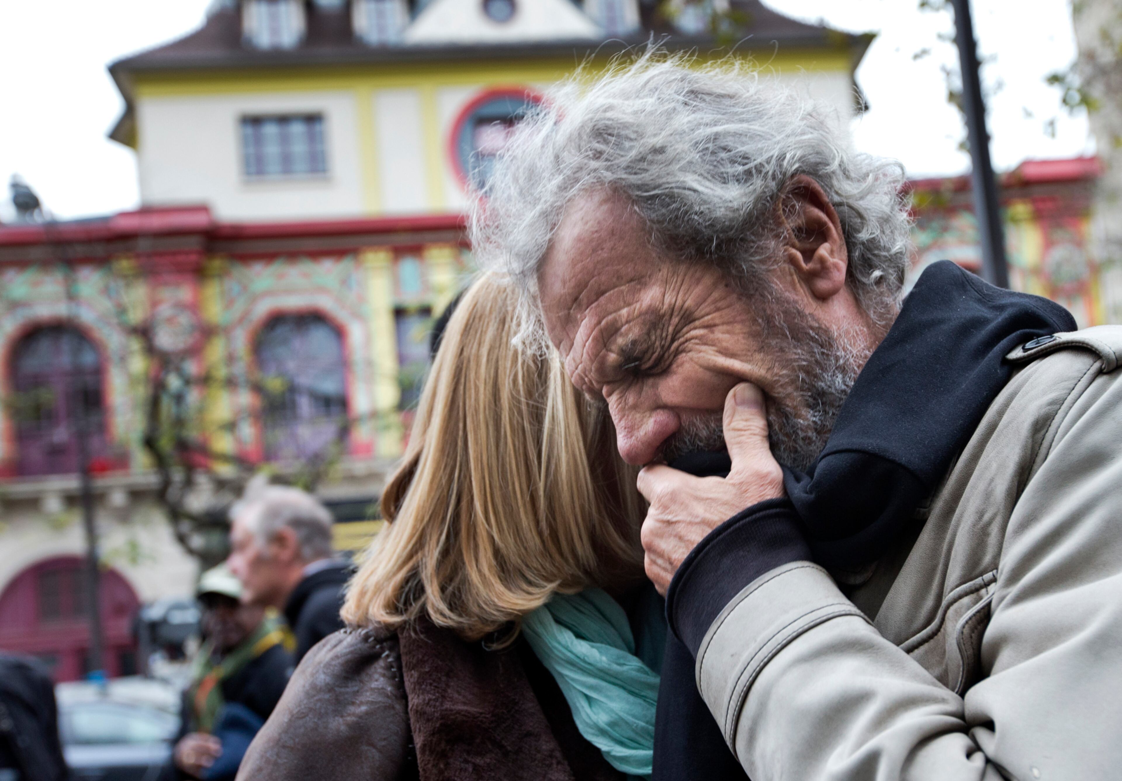 A FATHER'S GRIEF--Jean-Marie de Peretti mourns the loss of his 33-year-old daughter Aurelie, one of the victims of the attack on the Bataclan concert hall, rear, a site of last Friday's attacks, in Paris, Tuesday, Nov. 17, 2015. France is demanding security aid and assistance from the European Union in the wake of the Paris attacks and has triggered a never-before-used article in the EU's treaties to secure it. (AP Photo/Peter Dejong)