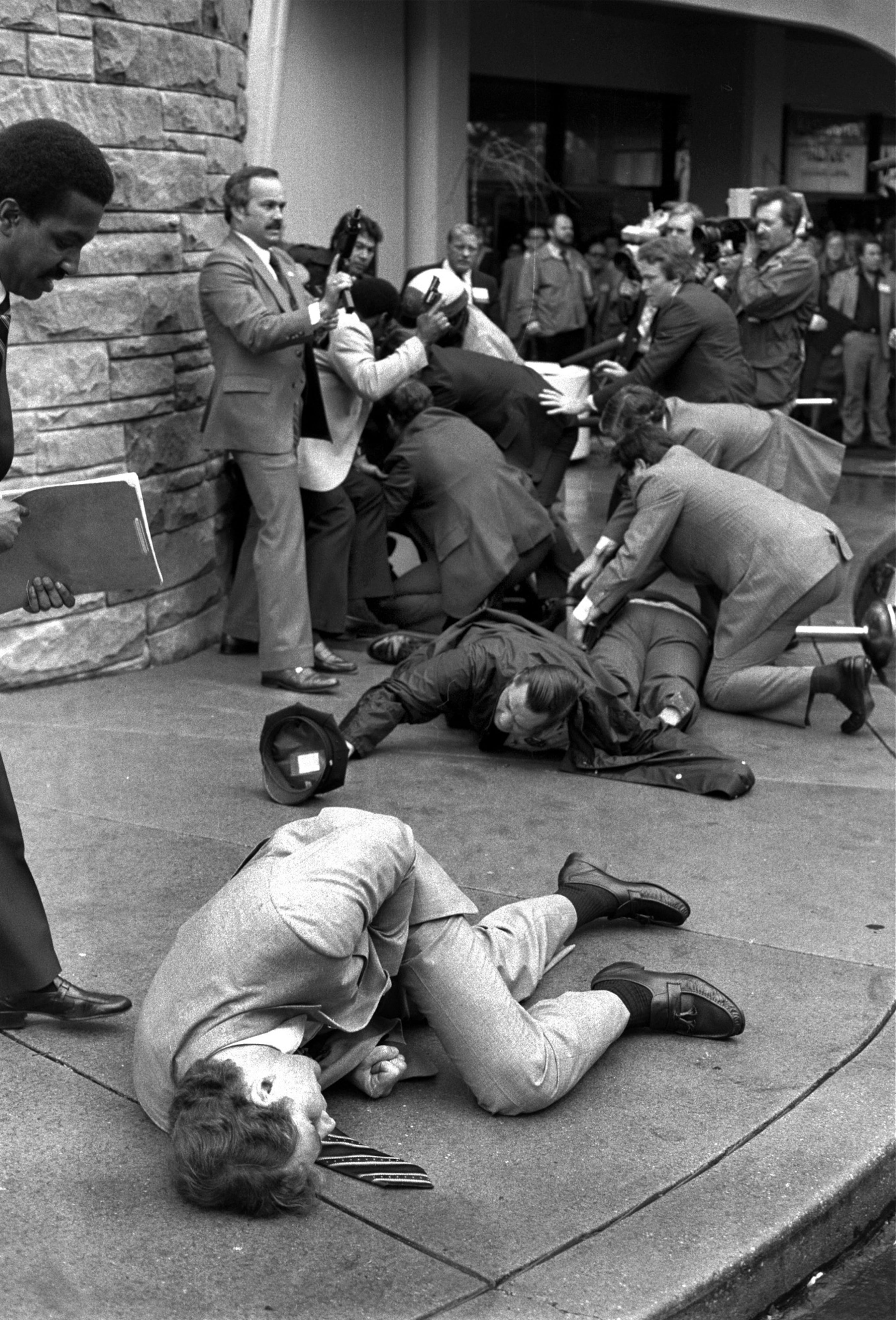 FILE - In this March 30, 1981 file photo, Secret Service agent Timothy J. McCarthy, foreground, Washington police officer, Thomas K. Delehanty, center, and presidential Press Secretary, James Brady, background, lie wounded on a street outside a Washington hotel after shots were fired at U.S. President Reagan on March 30, 1981. Twenty years later McCarthy, who threw himself into the line of fire taking a bullet intended for President Reagan, is now a police chief in a Chicago suburb. His heroism that day underpinned a campaign for statewide political office a few years ago that did not work out. (AP Photo/Ron Edmonds/File)