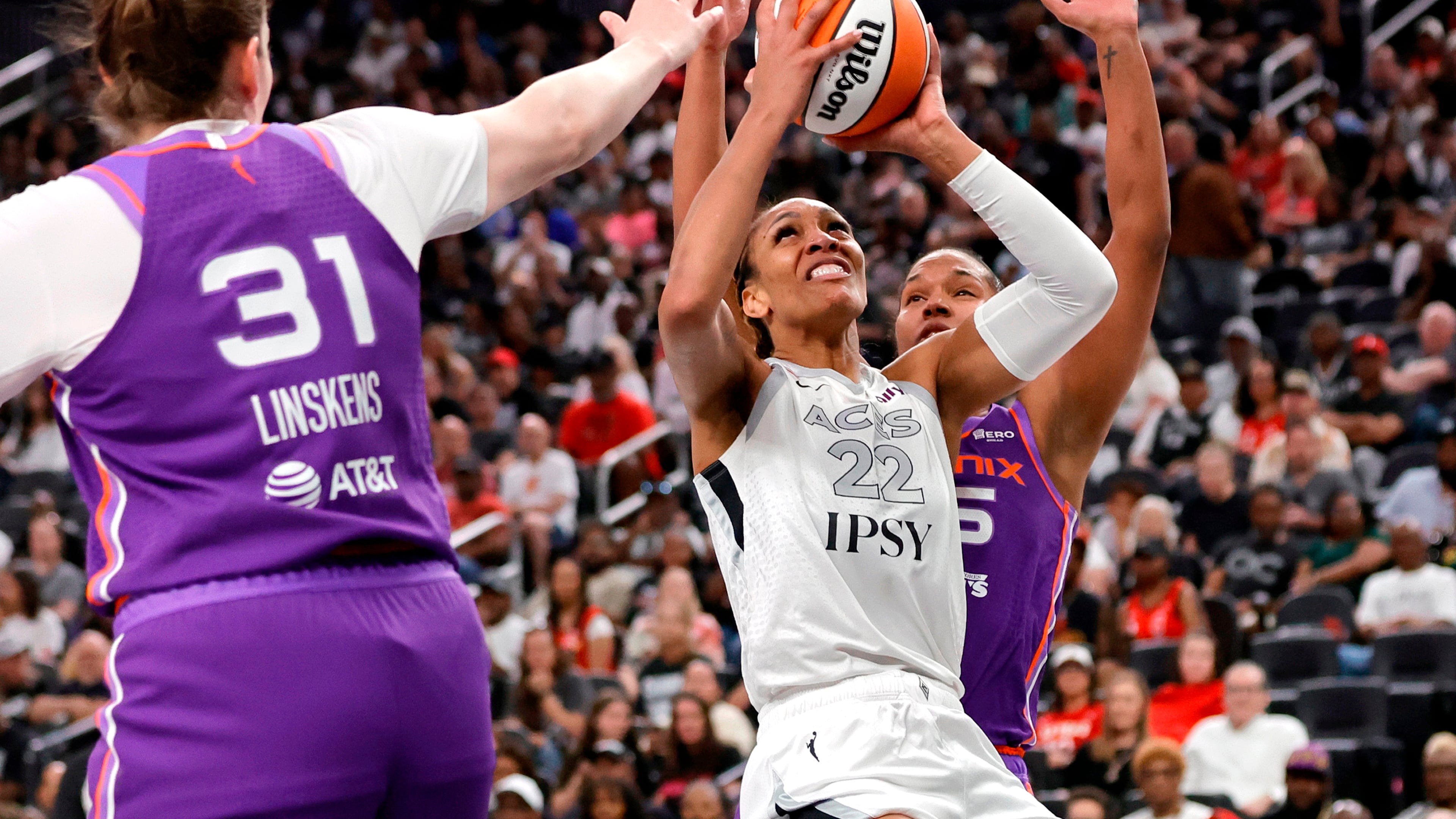 Las Vegas Aces center A'ja Wilson (22) looks to shoot between Phoenix Mercury center Kyara Linskens (31) and forward Alyssa Thomas, right, during the first half of an WNBA basketball game Saturday, May 9, 2026, in Las Vegas. (Steve Marcus/Las Vegas Sun via AP)