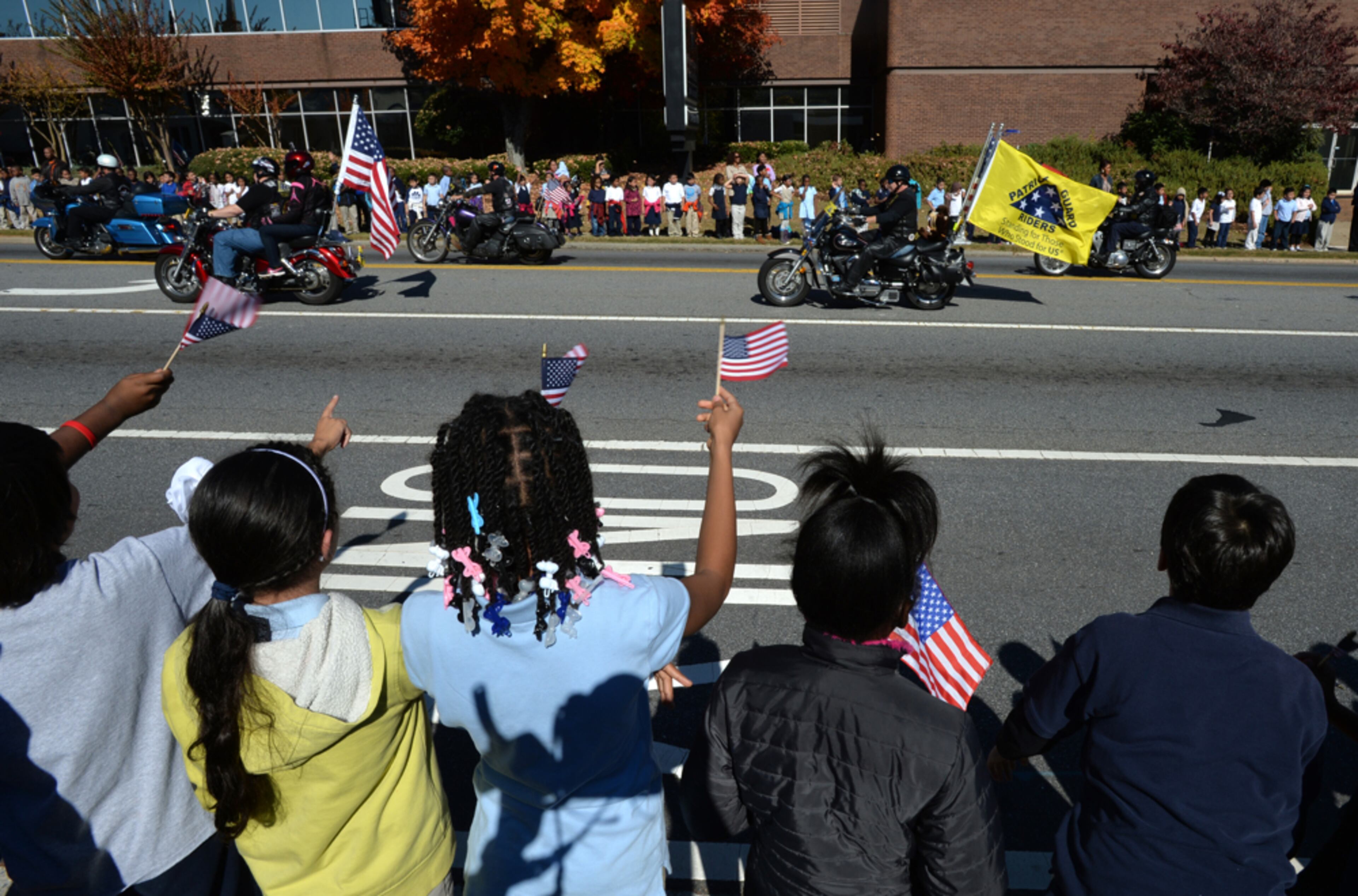 MARIETTA VETERANS DAY--The crowd waves flags as Patriot Guard Riders members march past along Roswell Street during the 10th annual Marietta Veterans Day Parade at Roswell Street Baptist Church in Marietta on Tuesday, November 11, 2014. The 10th annual Marietta Veterans Day Parade takes place begins at 11am at Roswell Street Baptist Church, loops through Marietta Square, and ends between the Cobb Courthouse and Marietta City Hall. The patriotic parade includes marching bands, drill teams, floats, military vehicles and veterans' organizations. The parade has both Marietta and Cobb County schools represented by their bands and their JROTC units. HYOSUB SHIN / HSHIN@AJC.COM (FILE)