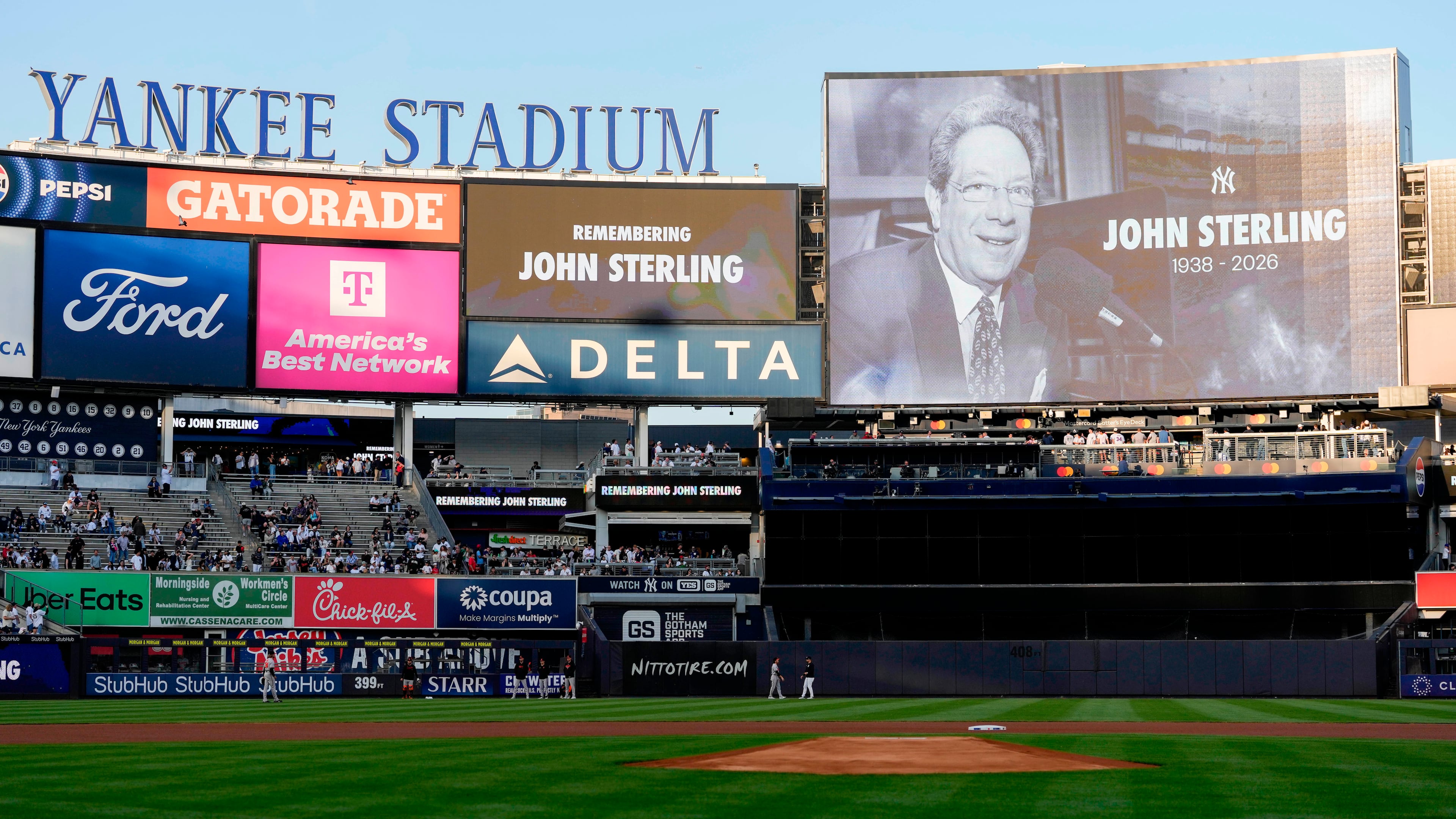 A scoreboard displays late former New York Yankees broadcaster John Sterling during a tribute to Sterling ahead of a baseball game between the New York Yankees and the Baltimore Orioles, Monday, May 4, 2026, in New York. (AP Photo/Yuki Iwamura)