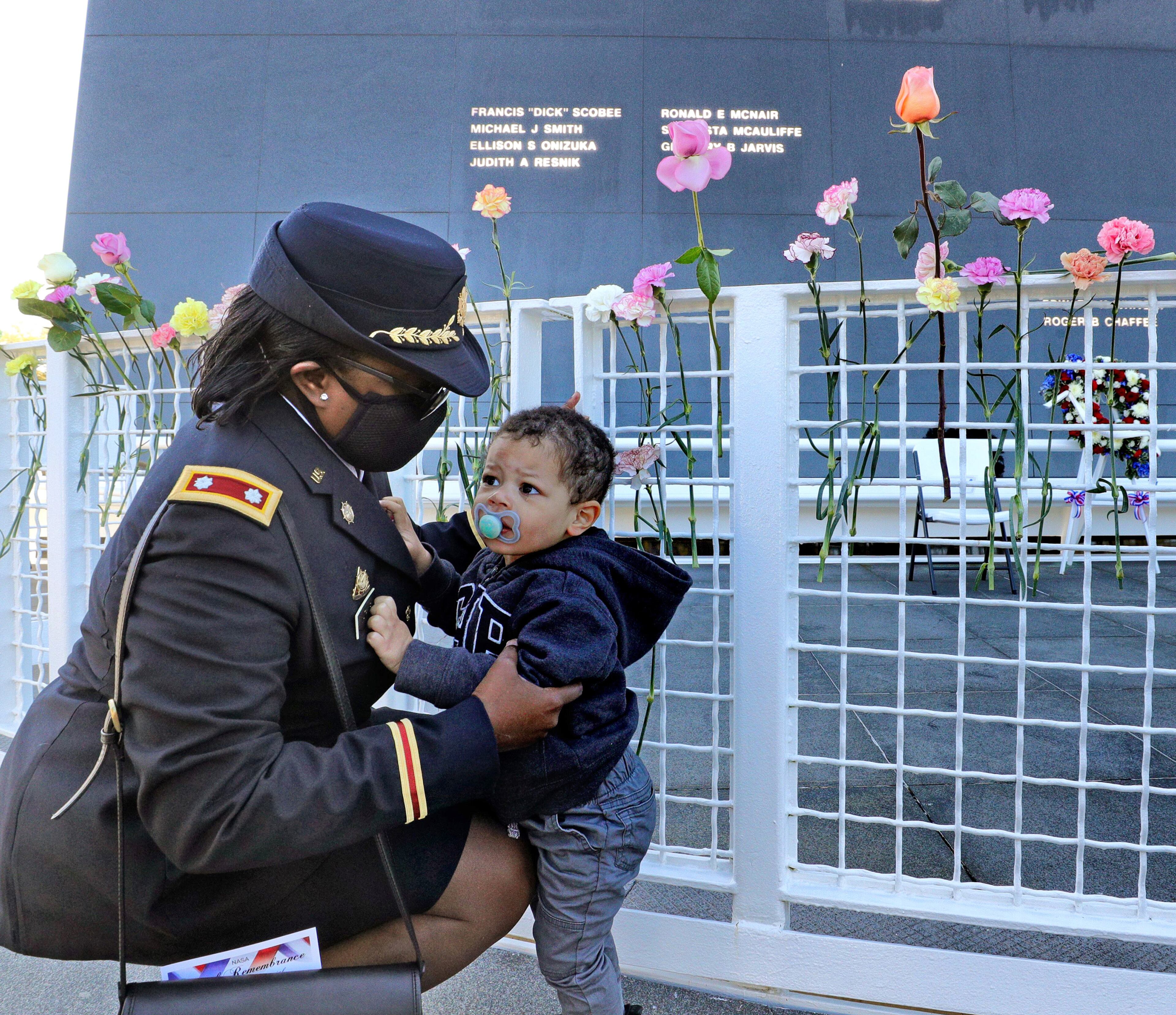 U.S. Army Lt. Col. retired Cynthia Watkins holds her grandson, 2-year-old Abel Williams, after placing a flower during the Day of Remembrance ceremony. (Joe Burbank/Orlando Sentinel/TNS)