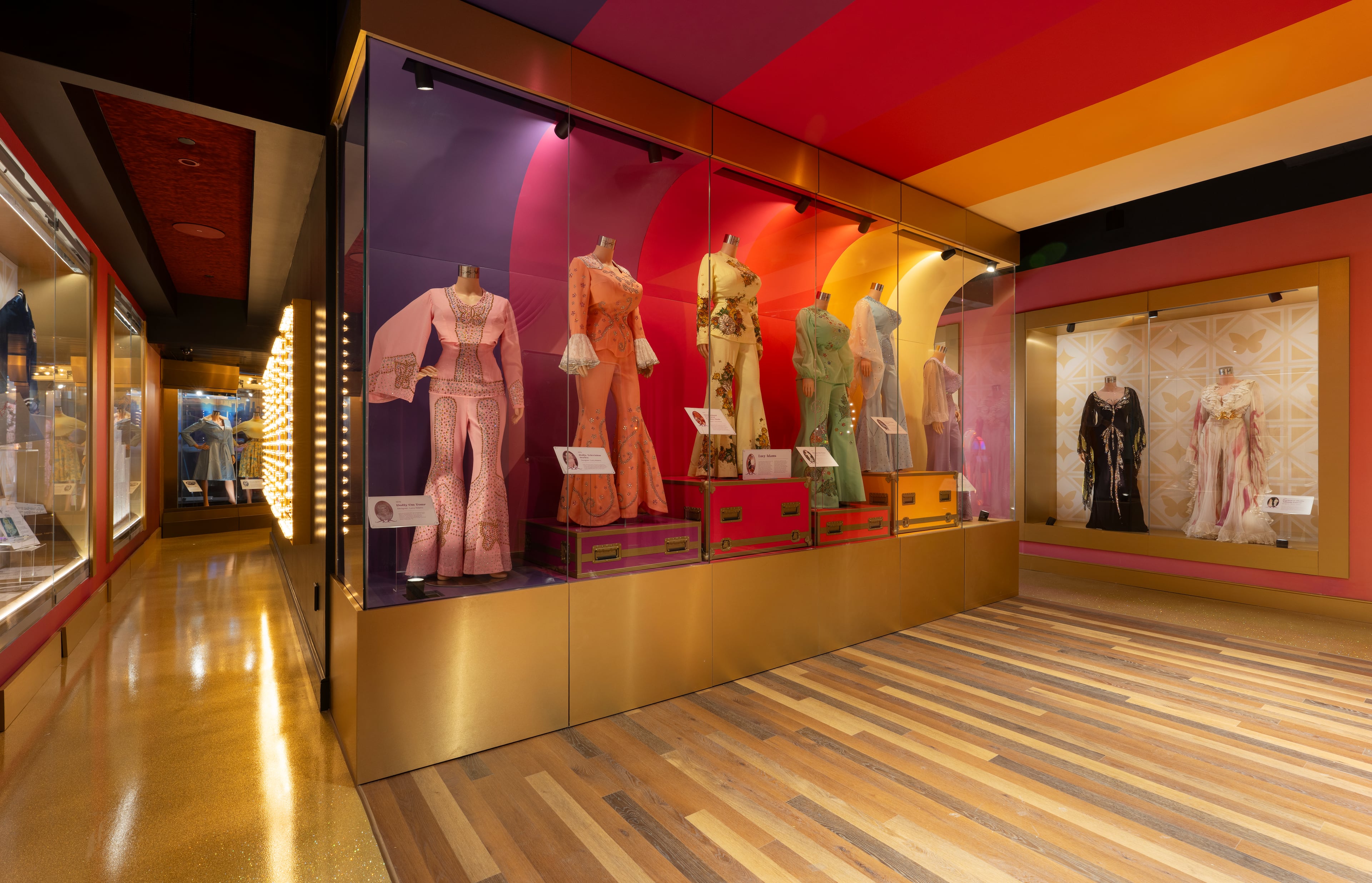 Dolly Parton’s signature style is on display in a collection of colorful, rhinestone-covered jumpsuits that reflect her larger-than-life stage presence. (Results Global/courtesy of Dolly Parton's Life of Many Colors Museum)