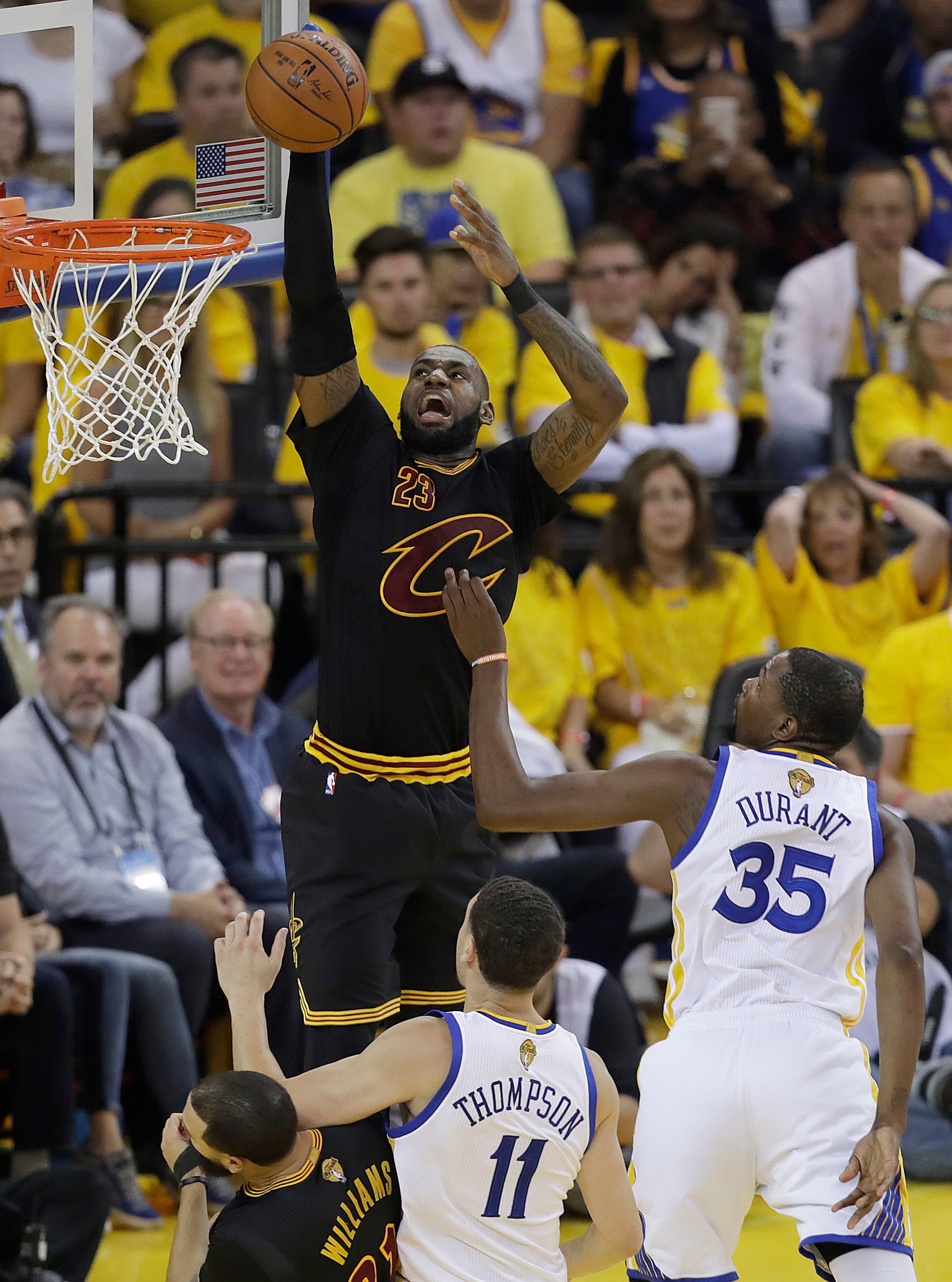 Cleveland Cavaliers forward LeBron James (23) dunks over Golden State Warriors guard Klay Thompson (11) and forward Kevin Durant (35) during the first half of Game 5 of basketball's NBA Finals in Oakland, Calif., Monday, June 12, 2017. (AP Photo/Marcio Jose Sanchez)