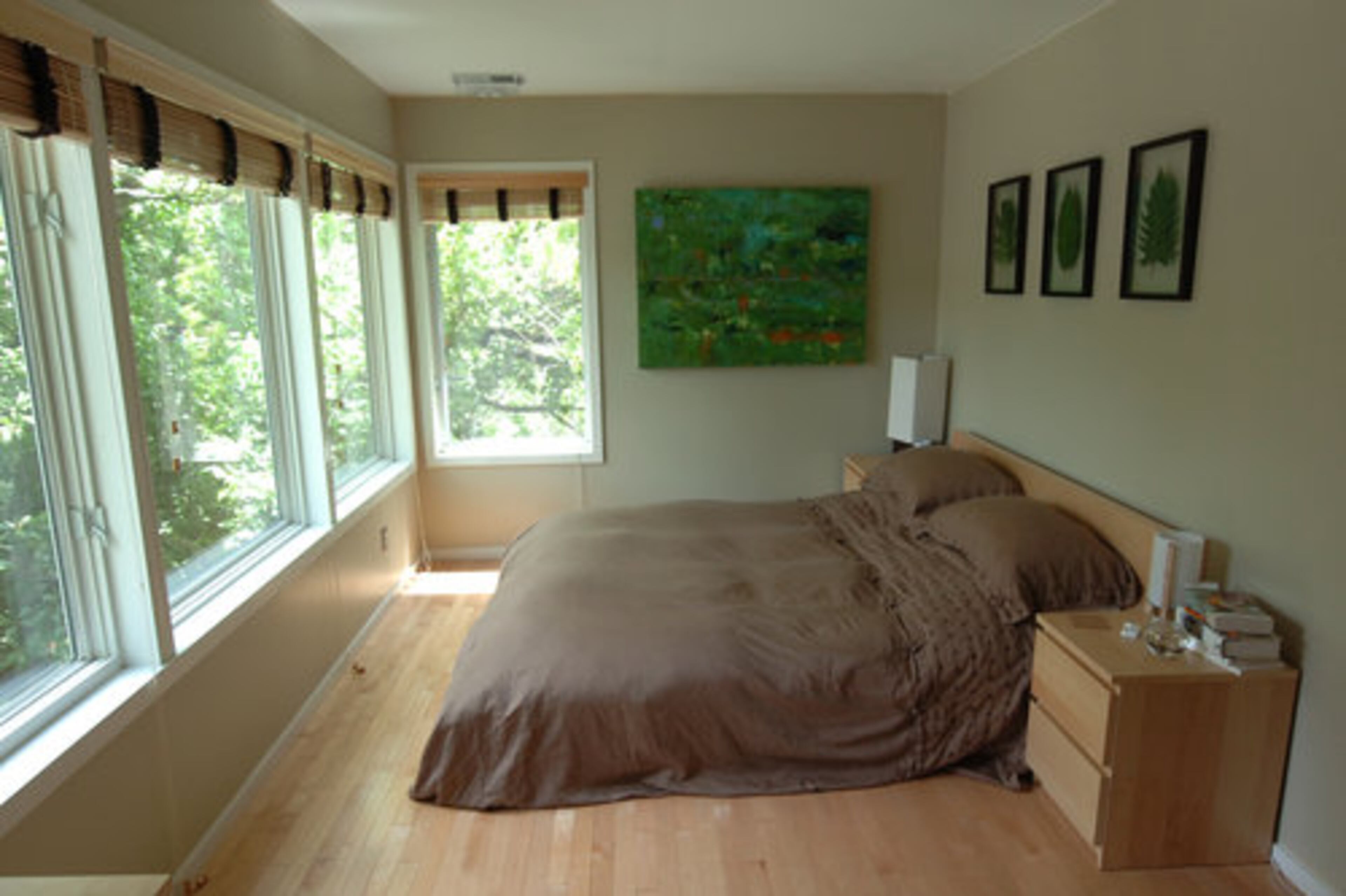 From the front door, metal stairs lead to the master bedroom where more tall windows let in natural light. Custom-made wood blinds provide privacy when needed.