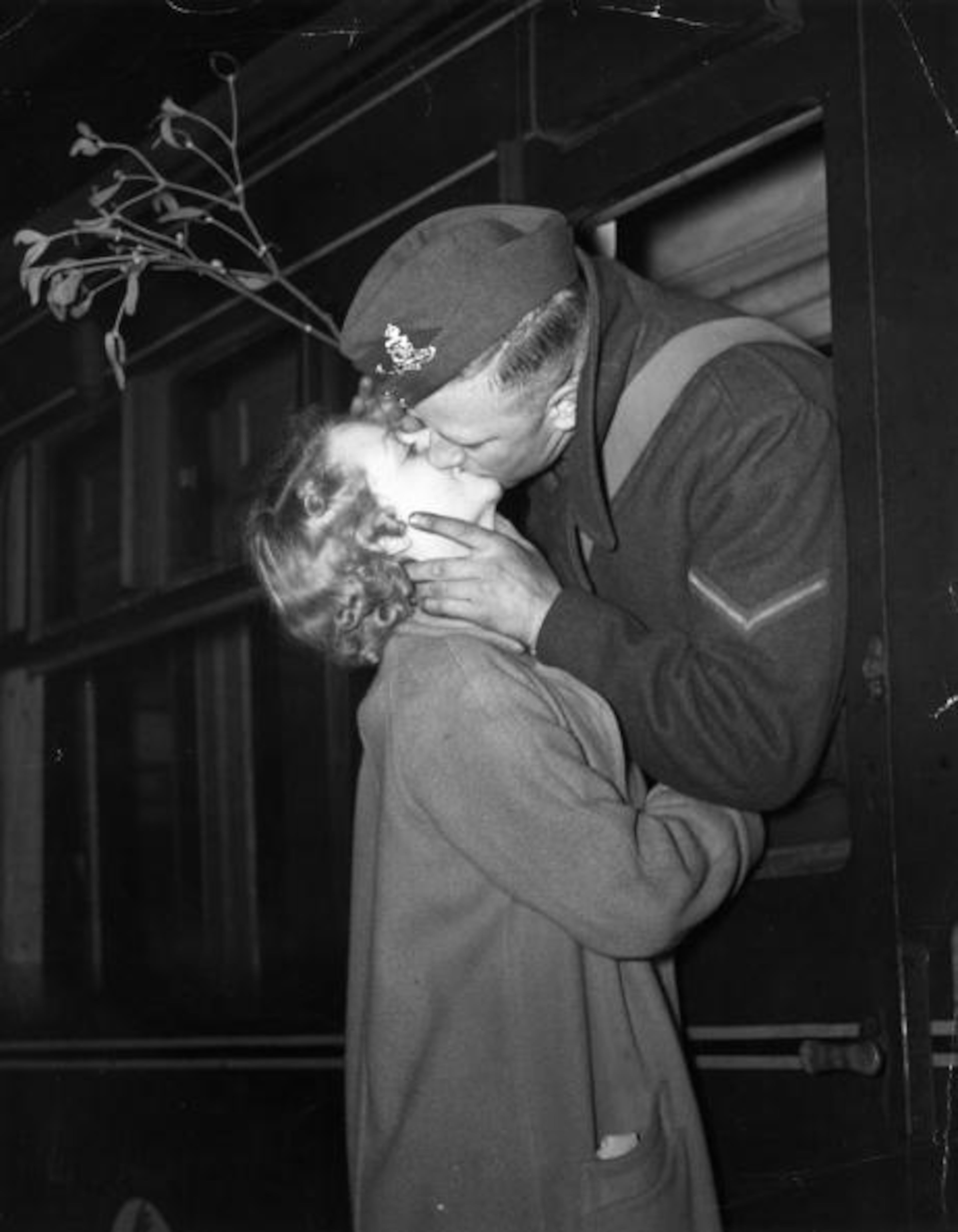 A soldier leaving a London railway station to re-join his unit took along a sprig of mistletoe to make sure he got his Christmas kiss on Dec. 14, 1939. (Photo by Gerry Cranham/Fox Photos/Getty Images)