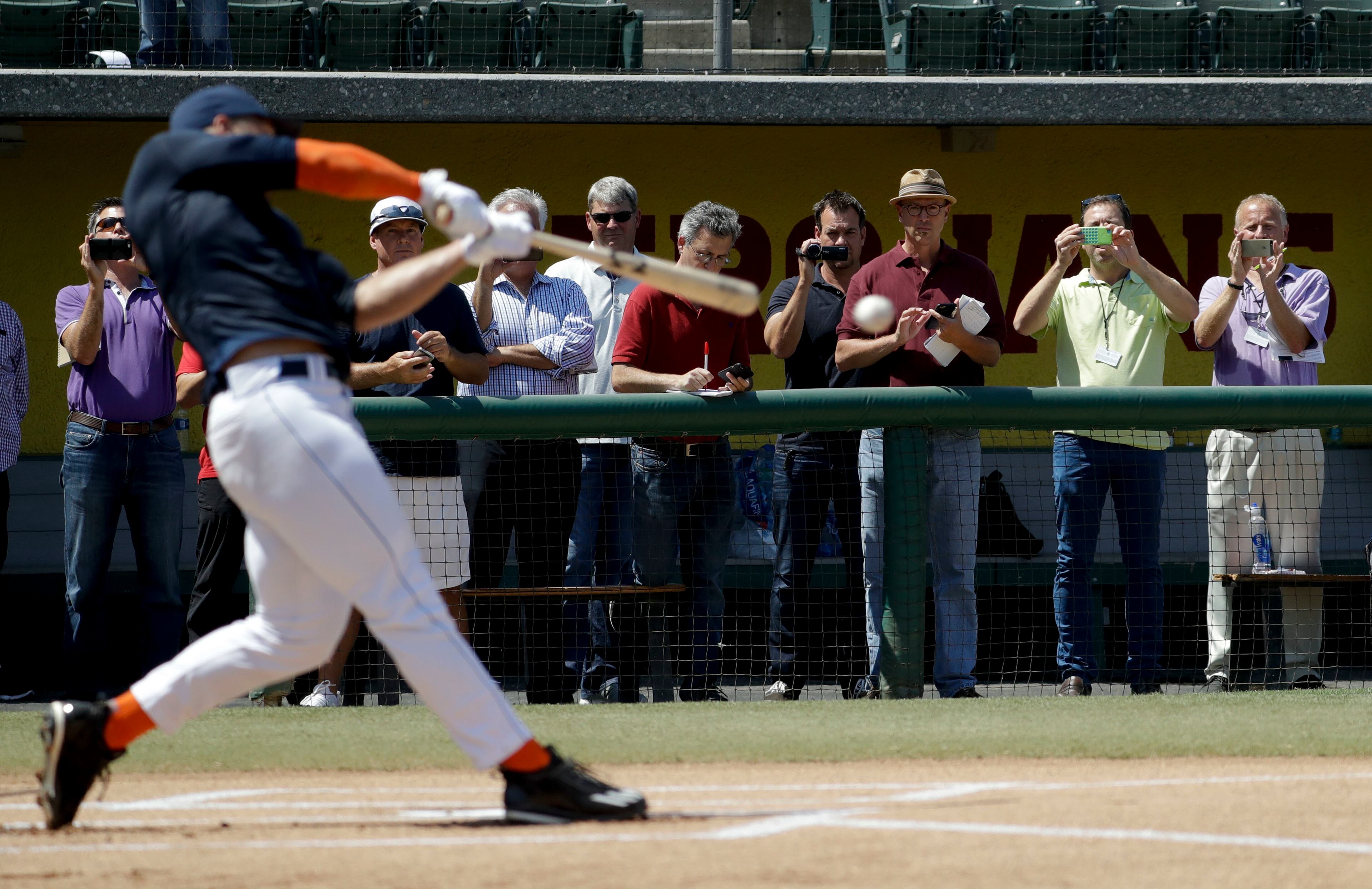 Baseball scouts and the media watch a showcase for former NFL quarterback, Tim Tebow at the University of Southern California, Tuesday, Aug. 30, 2016 in Los Angeles. The Heisman Trophy winner works out for a big gathering of scouts on USC's campus in an attempt to start a career in a sport he hasn't played regularly since high school. (AP Photo/Chris Carlson)