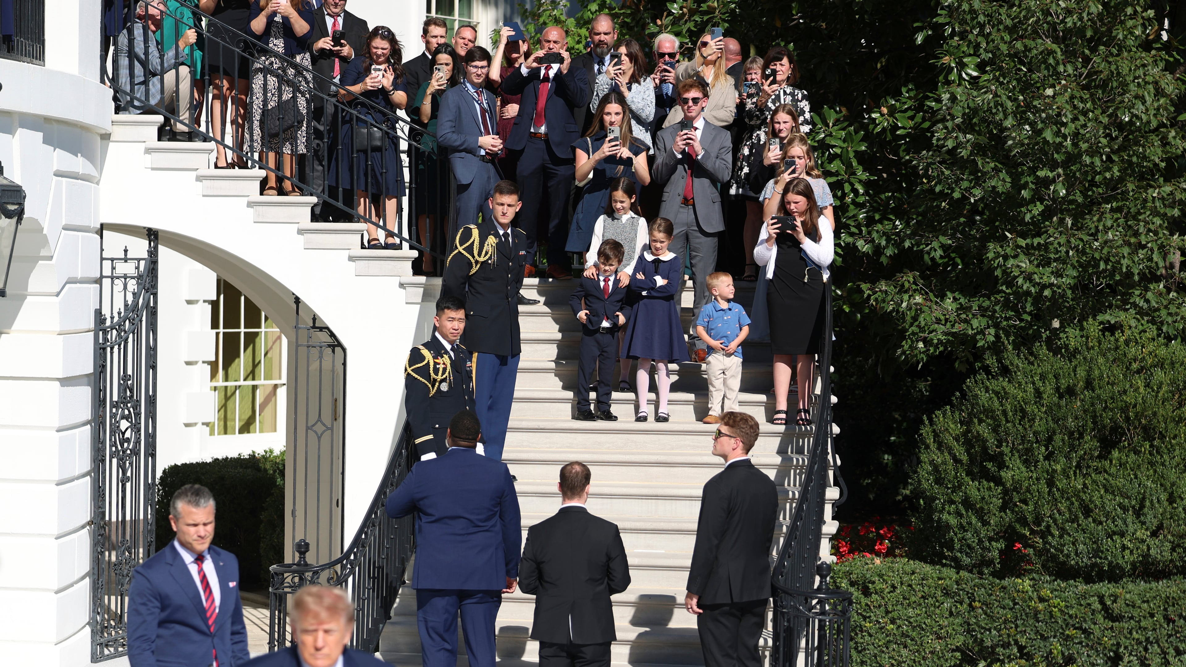 Gold Star families watch as President Donald Trump and Defense Secretary Pete Hegseth walk before departing on Marine One from the South Lawn of the White House, Tuesday, Oct. 6, 2026, in Washington. (AP Photo/Tom Brenner)