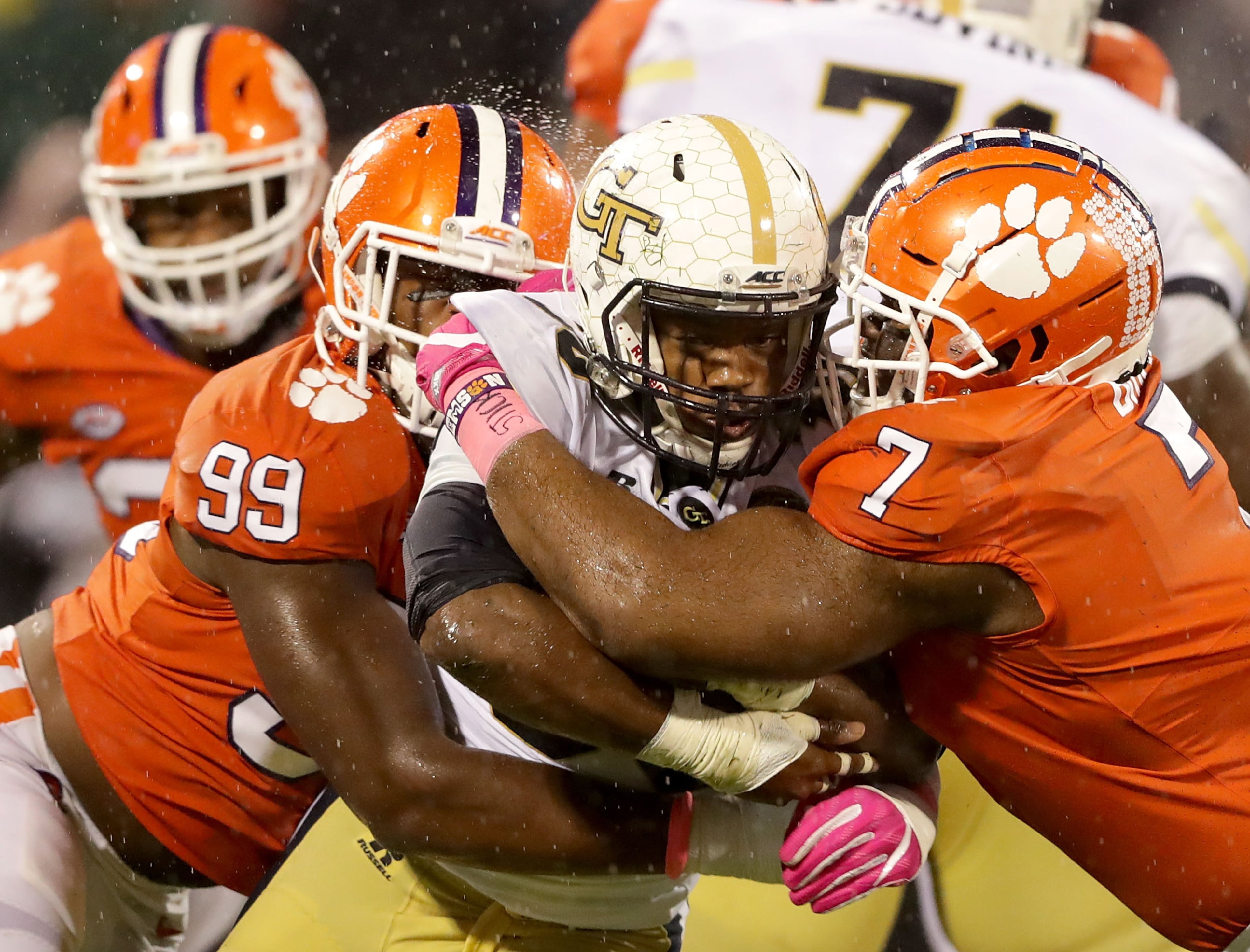 CLEMSON, SC - OCTOBER 28: Teammates Clelin Ferrell #99 and Austin Bryant #7 of the Clemson Tigers try to stop KirVonte Benson #30 of the Georgia Tech Yellow Jackets during their game at Memorial Stadium on October 28, 2017 in Clemson, South Carolina. (Photo by Streeter Lecka/Getty Images)