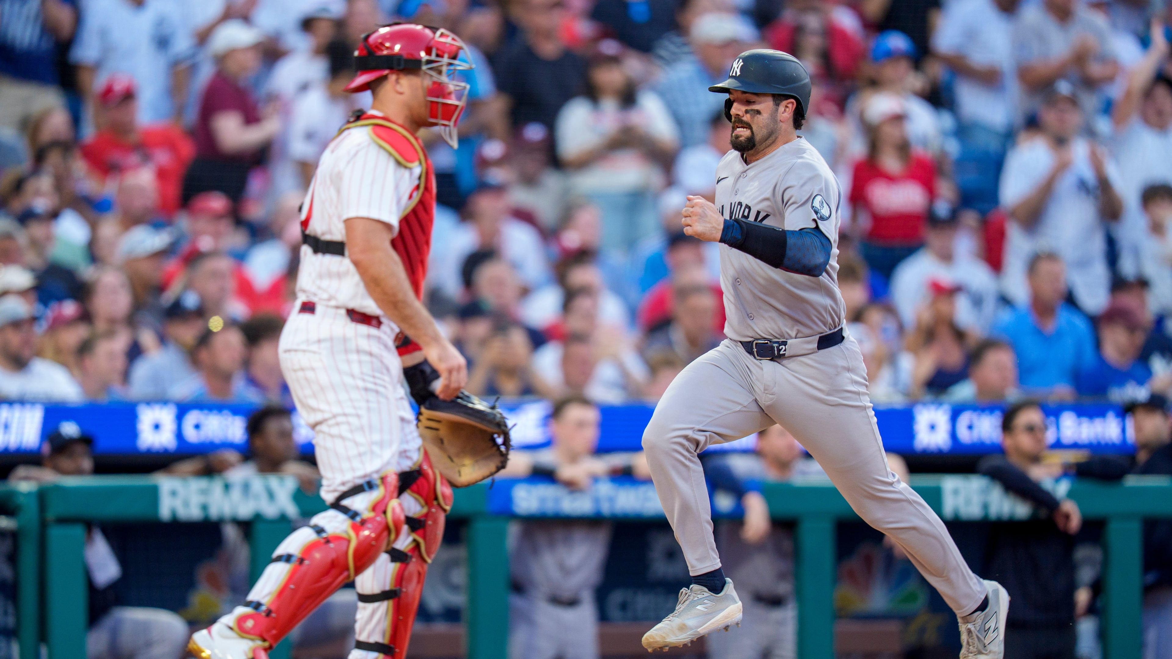 New York Yankees' Austin Wells, right, comes in to score on the single by Cody Bellinger as Philadelphia Phillies catcher J.T. Realmuto, left, looks on during the sixth inning of a baseball game, Saturday, July 25, 2026, in Philadelphia. (AP Photo/Chris Szagola)
