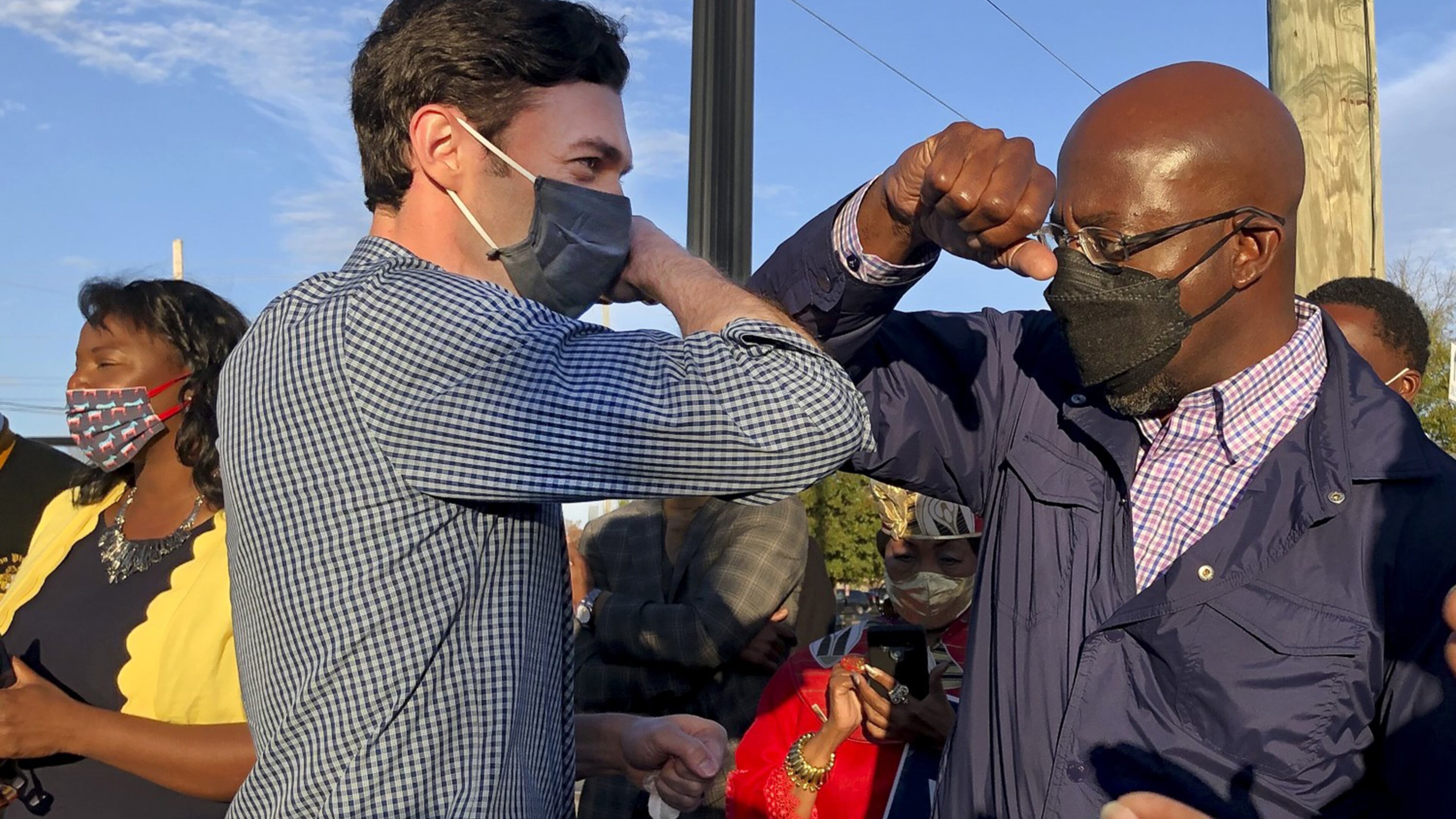 Georgia's Democratic U.S. Senate candidates Jon Ossoff, left, and Raphael Warnock tap elbows during a rally for supporters on November 15, 2020, in Marietta, Georgia. (Jenny Jarvie/Los Angeles Times/TNS)