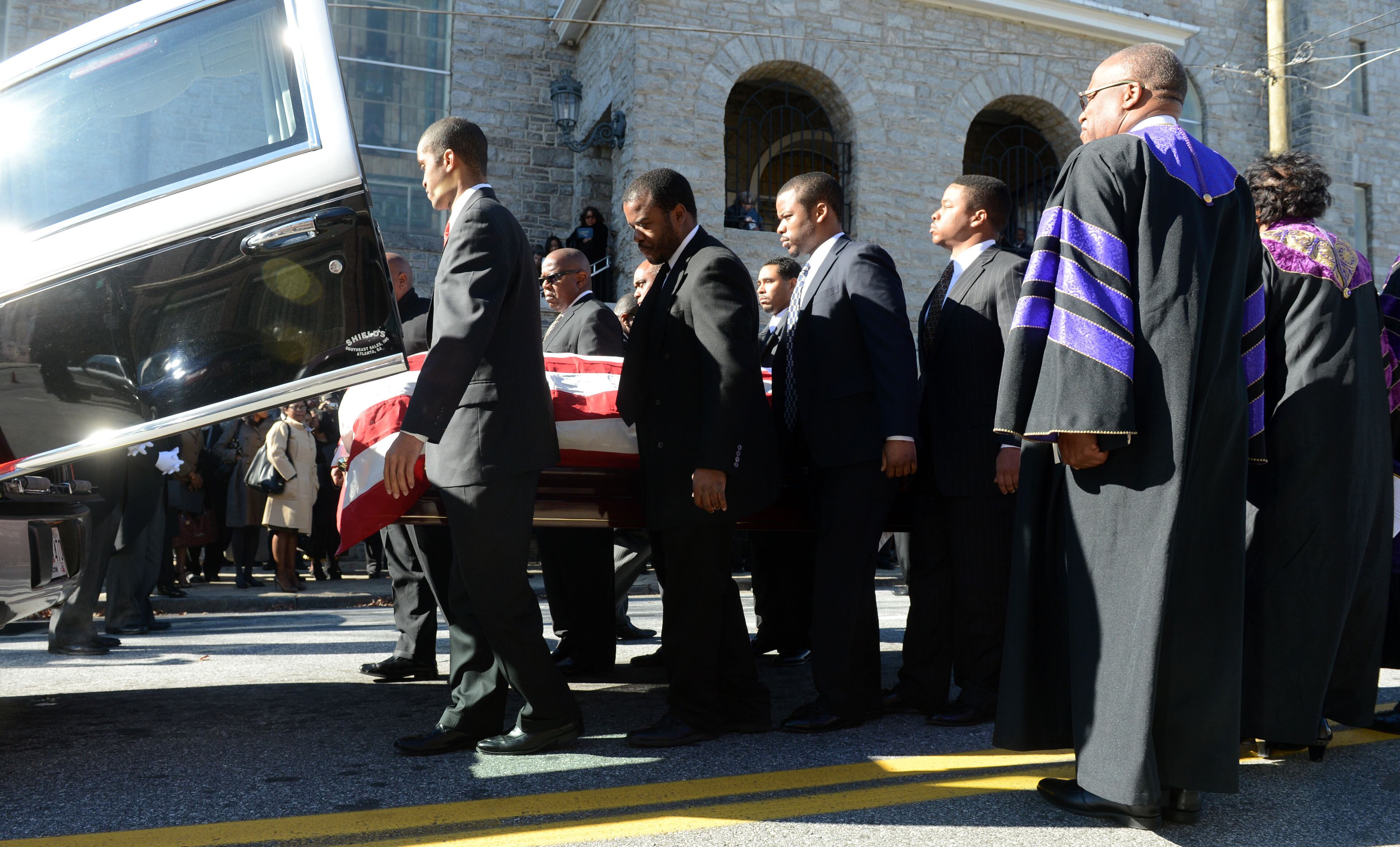 Pallbearers load the casket into a hearse at the conclusion of the funeral service.