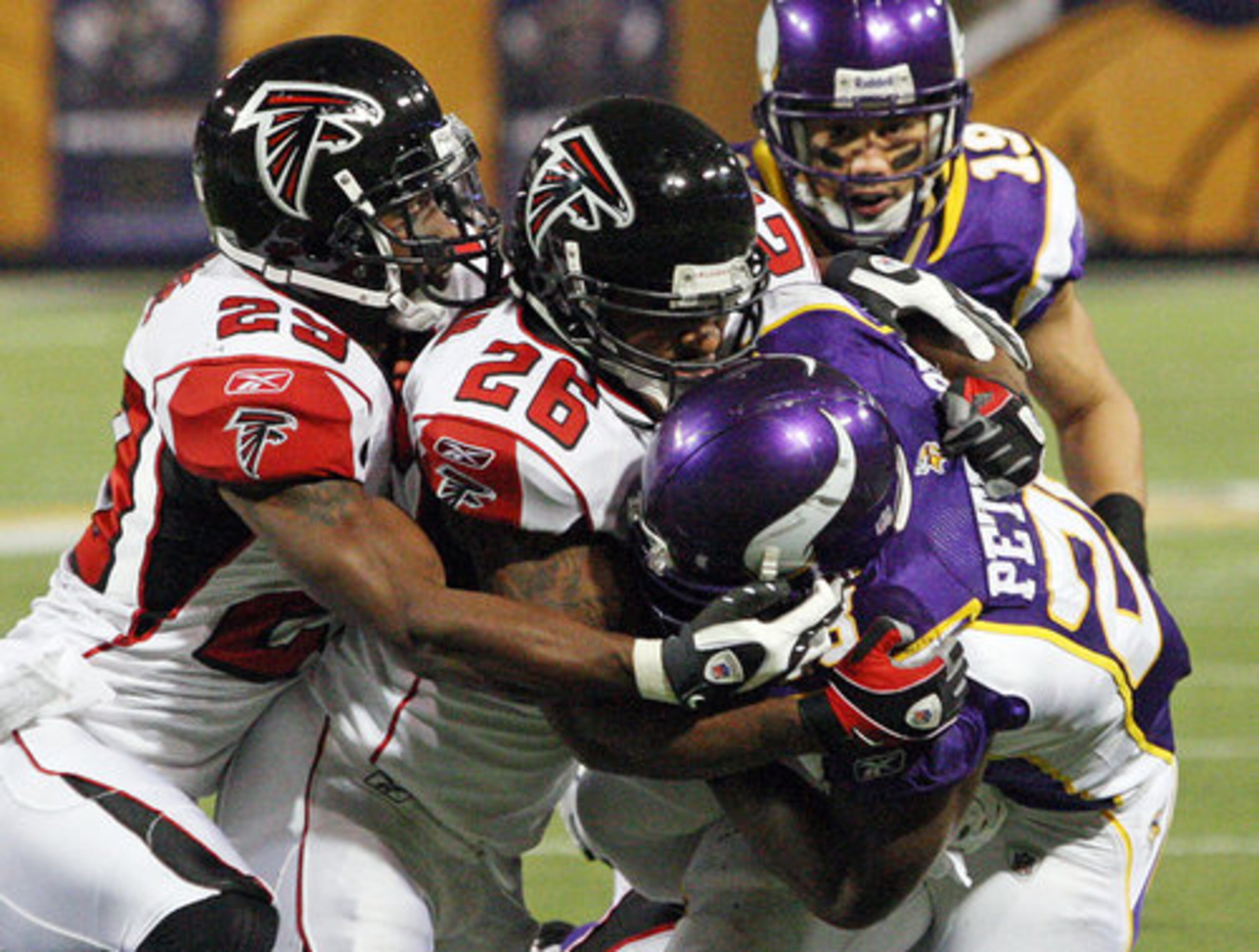 Falcons defenders swarm Vikings running back Adrian Peterson, the league's leading rusher. Peterson was held to 76 yards on 22 attempts.