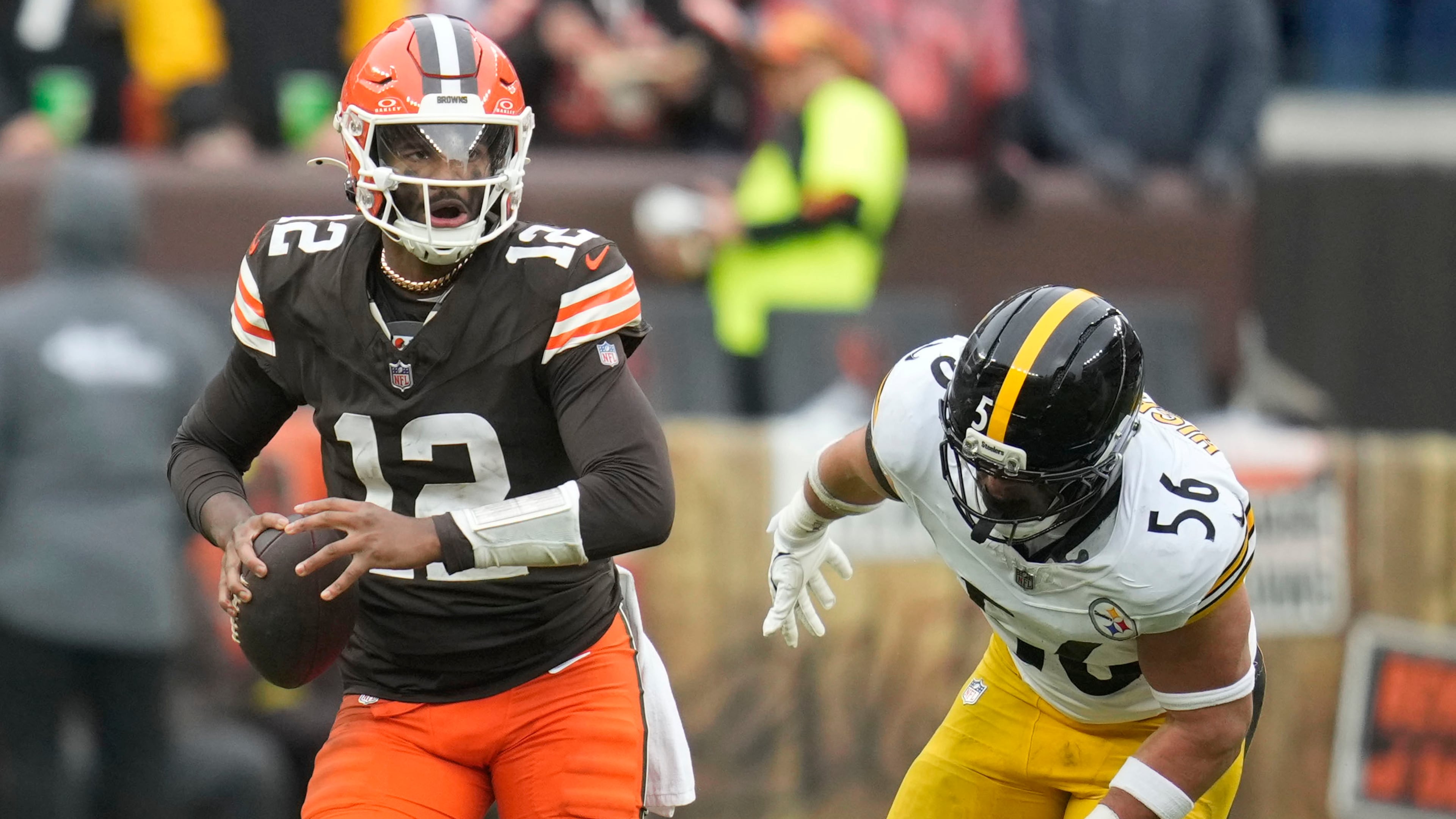 Cleveland Browns quarterback Shedeur Sanders (12) runs from Pittsburgh Steelers linebacker Alex Highsmith (56) during the second half of an NFL football game, Sunday, Dec. 28, 2025, in Cleveland. (AP Photo/Sue Ogrocki)
