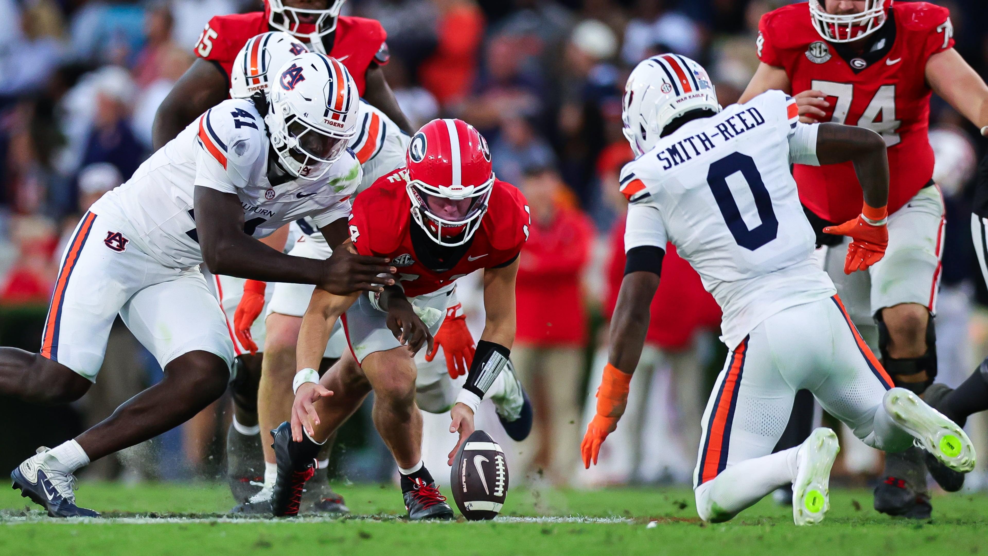Georgia quarterback Gunner Stockton, center, fumbles as Auburn defensive end Jared Smith, left, and defensive back Sylvester Smith-Reed (0) close in during the second half of an NCAA college football game, Saturday, Oct. 17, 2026, in Athens, Ga. (AP Photo/Colin Hubbard)