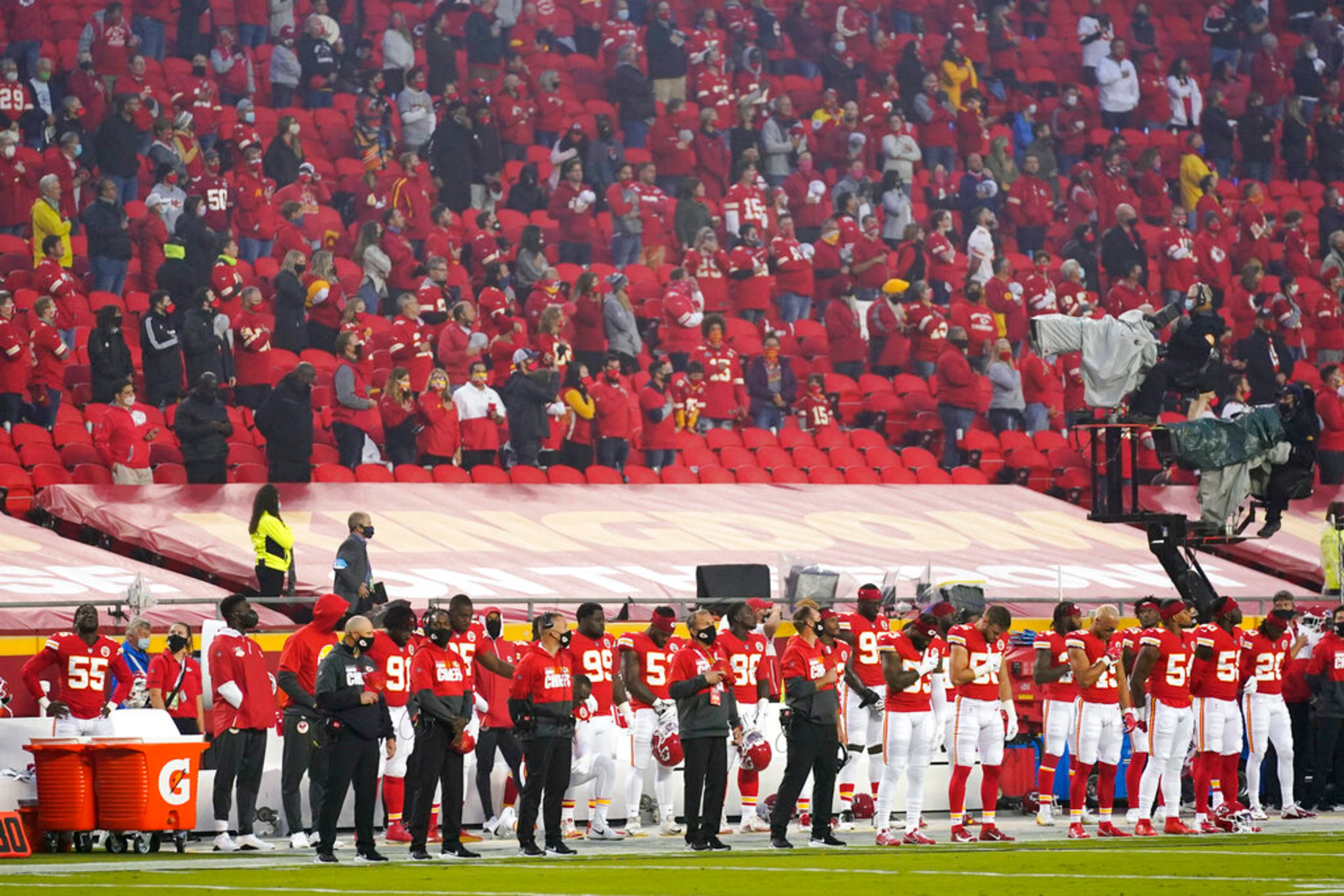 Kansas City Chiefs players and fans stand during the national anthem before an NFL football game against the Houston Texans Thursday, Sept. 10, 2020, in Kansas City, Mo. (AP Photo/Jeff Roberson)