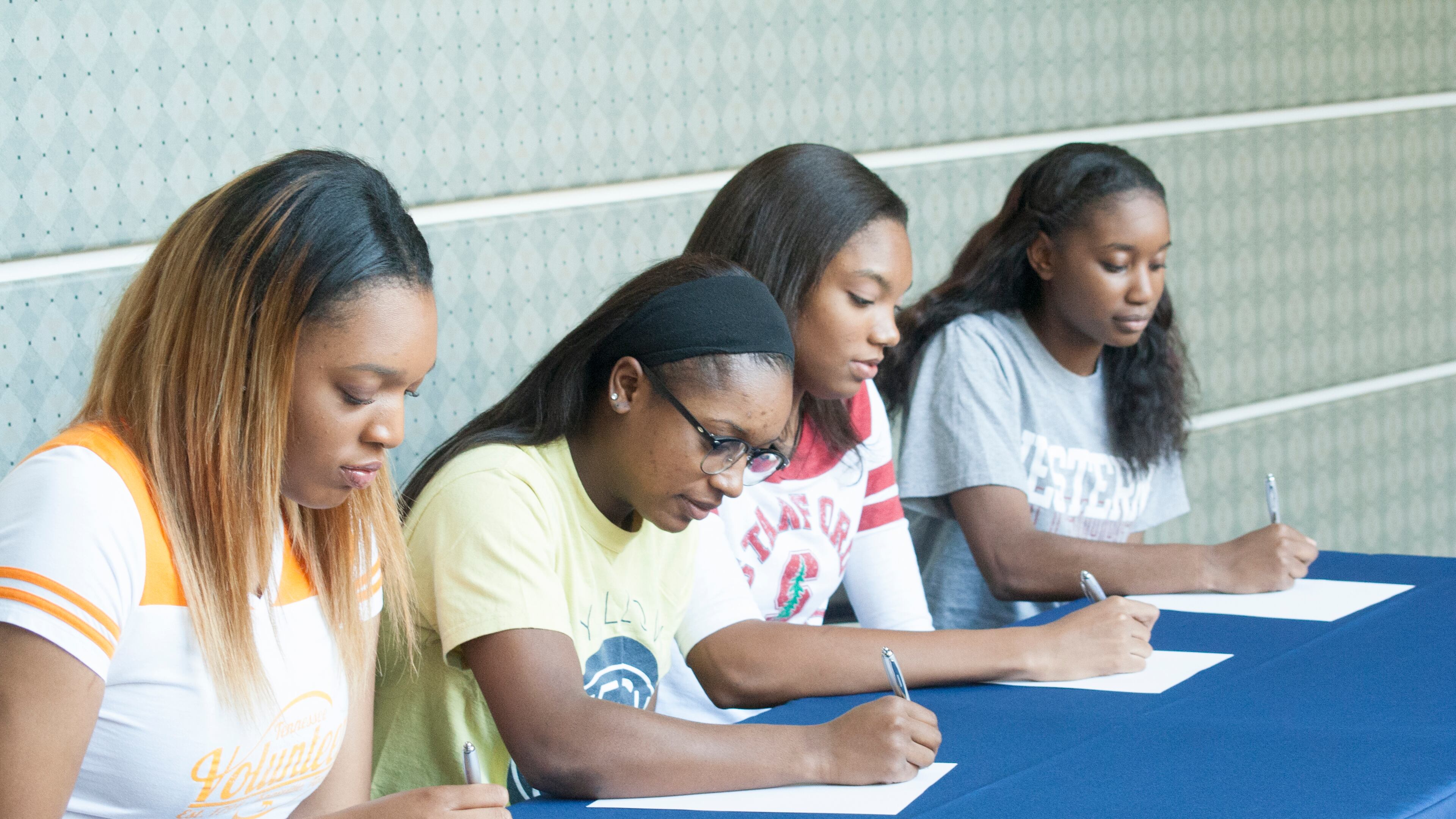 Kasiyahna Kushkituah (left), Taja Cummings, Maya Dodson and Nichel Tampa get ready to sign their national letters of intent. (Amber DeSantis/St. Francis High School)