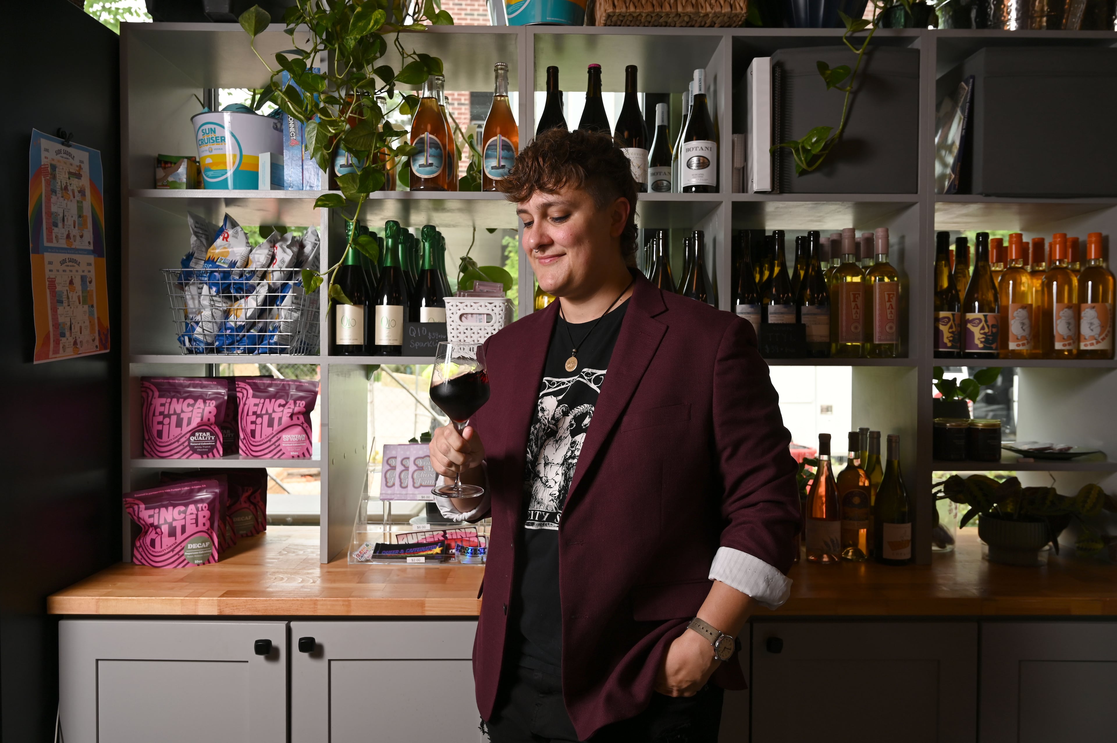 Jett Kolarik swirls a glass of wine at Side Saddle Wine Saloon and Bar in Atlanta on Thursday, June 18, 2026. Kolarik, who is currently the sommelier at Koshu Club, helped start the wine program at Side Saddle. (Hyosub Shin/AJC)