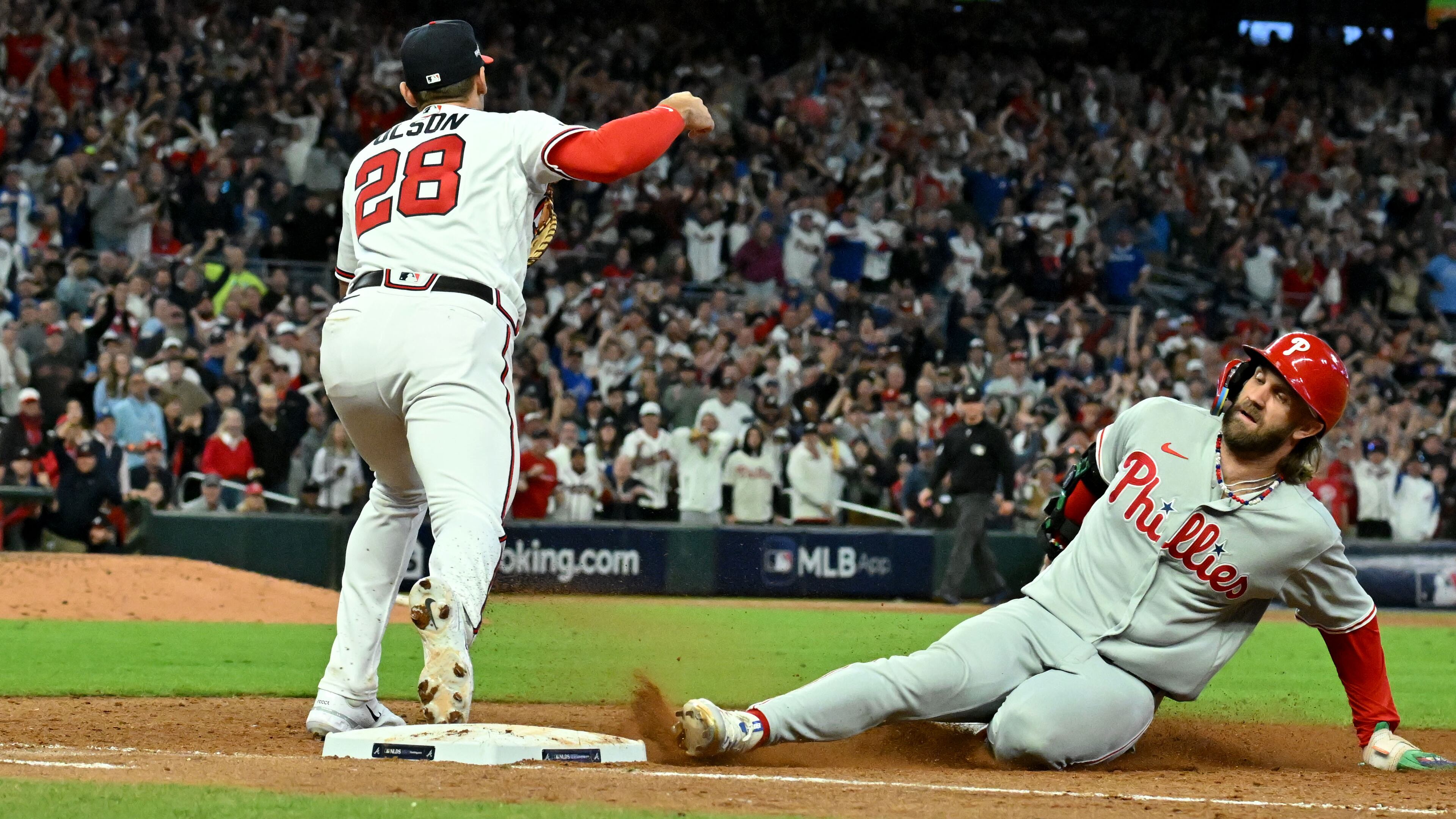 Atlanta Braves first baseman Matt Olson (28) forces out Philadelphia Phillies designated hitter Bryce Harper (3) after Philadelphia Phillies right fielder Nick Castellanos filed into a double play to end the ninth inning in the Game 2 of the 2023 National League Division Series at Truist Park, Monday, October 9, 2023, in Atlanta. Atlanta Braves won 5-4 over Philadelphia Phillies. (Hyosub Shin / Hyosub.Shin@ajc.com)