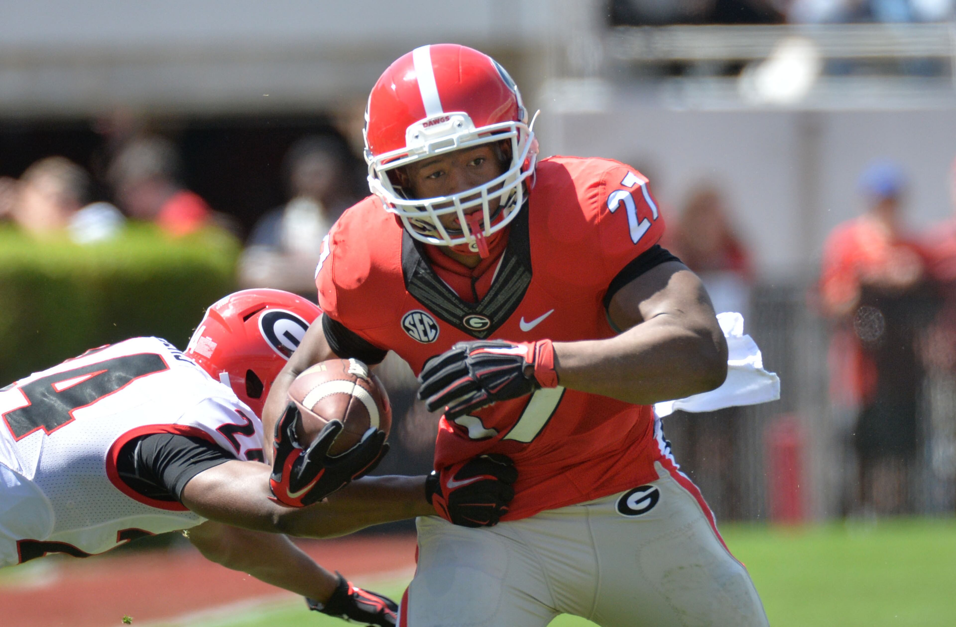 Georgia Bulldogs running back Nick Chubb (27) runs past Georgia Bulldogs defensive back Dominick Sanders (24) in the first half of the 2015 Georgia Bulldogs G-Day game at Sanford Stadium in Athens on Saturday, April 11, 2015. HYOSUB SHIN / HSHIN@AJC.COM